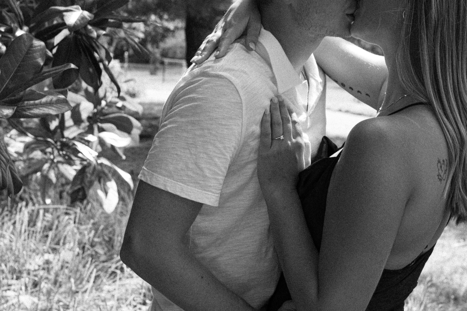 Intimate black and white portrait showing tender moment outdoors.