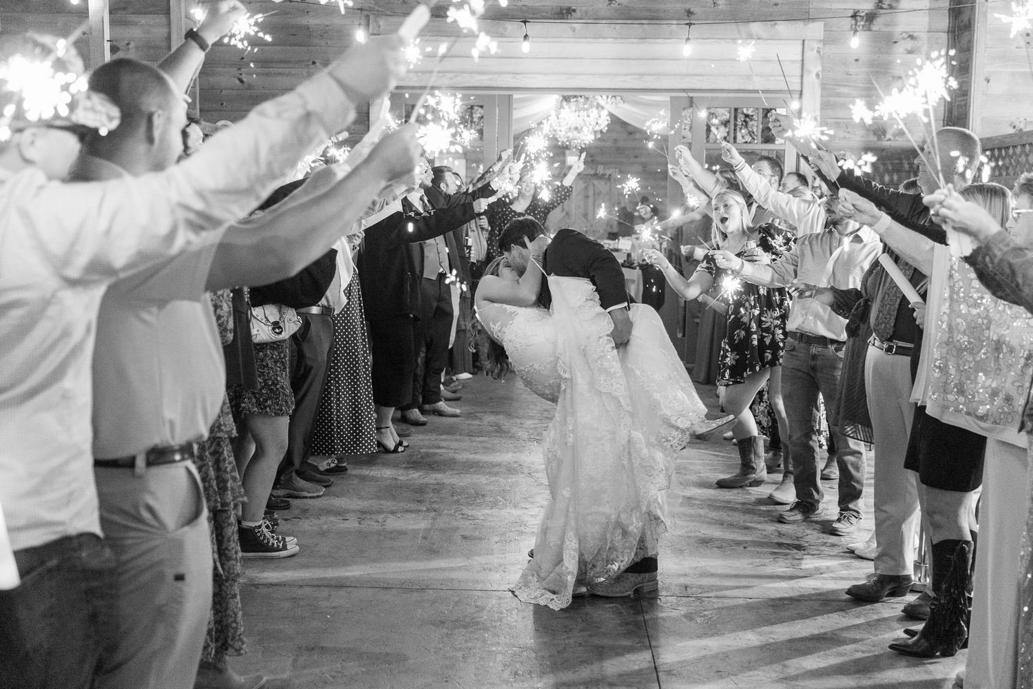 A sparkler exit creates a magical corridor of light as guests celebrate a wedding departure.
