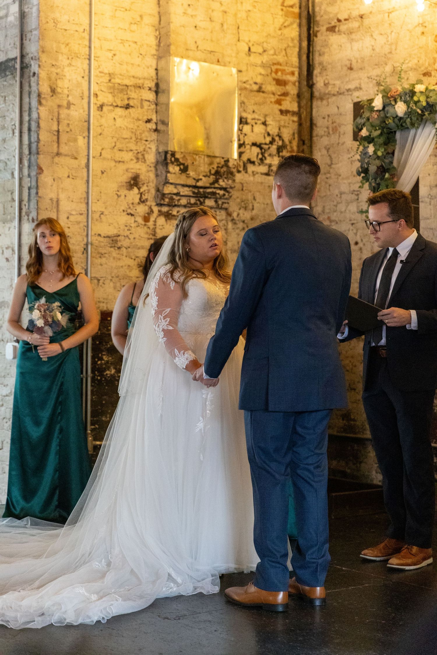 Wedding ceremony in industrial venue with exposed brick walls and elegant decor.