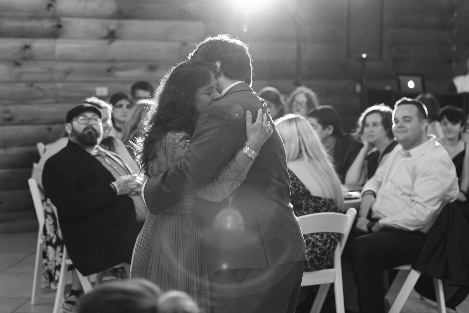 Black and white candid wedding reception photo with dance floor lighting.