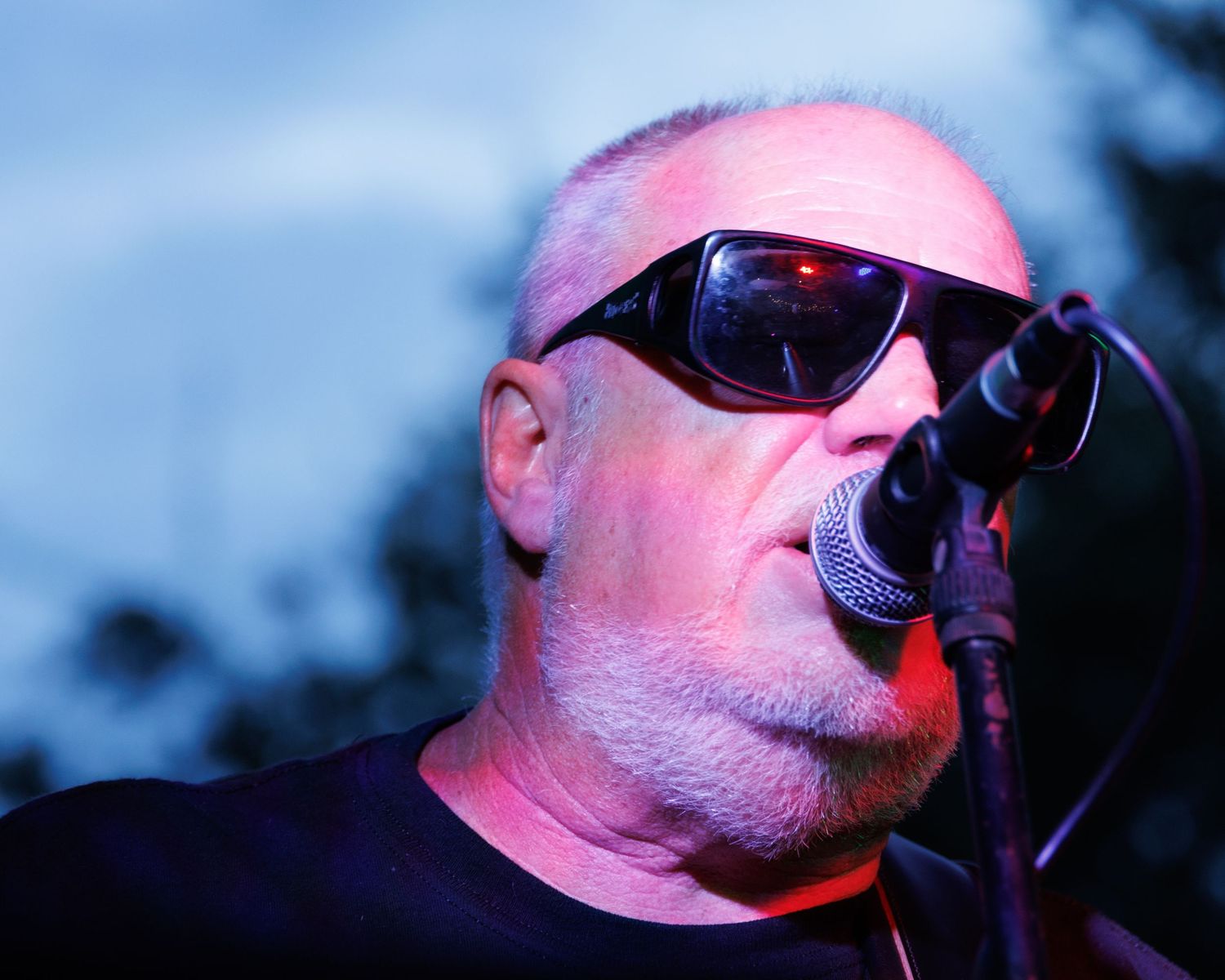 A series of close-up photos showing parts of a face wearing sunglasses under pink and blue lighting.