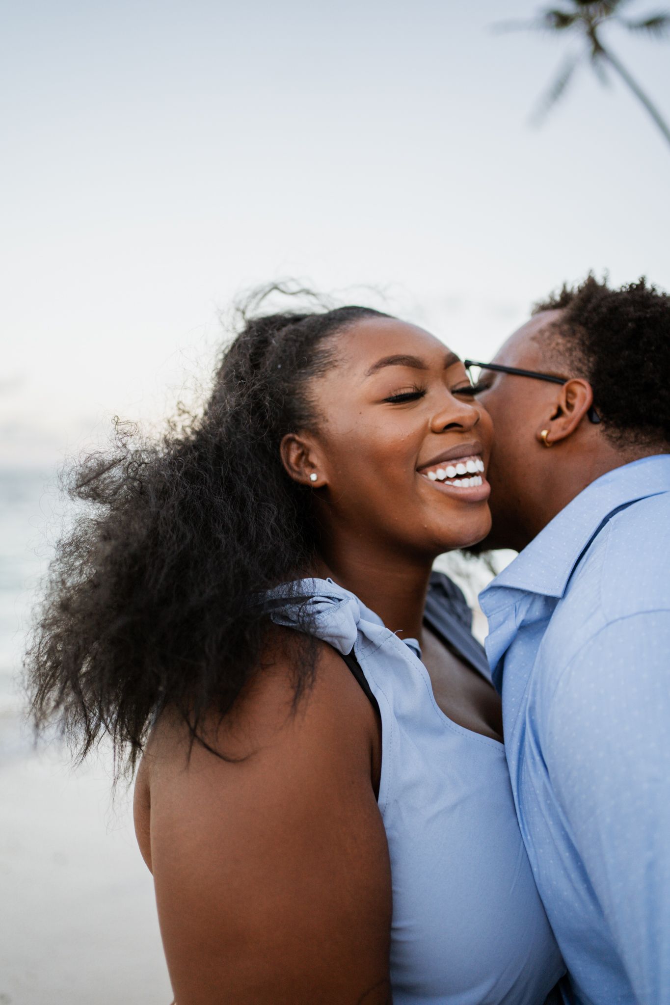 Intimate embrace captured against ocean backdrop during sunset photoshoot.
