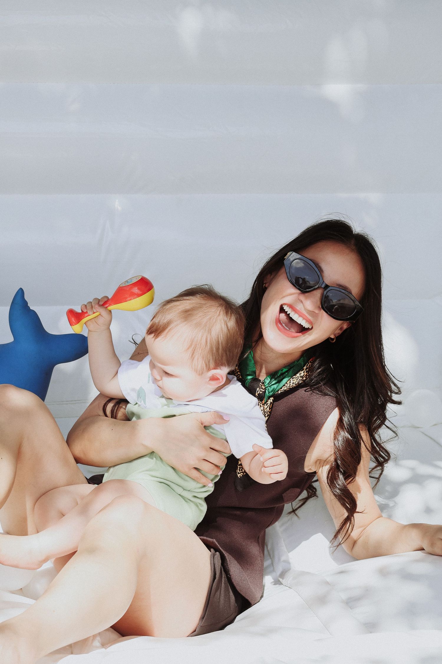A joyful beach scene with sunglasses and a toy shark on a sunny day.