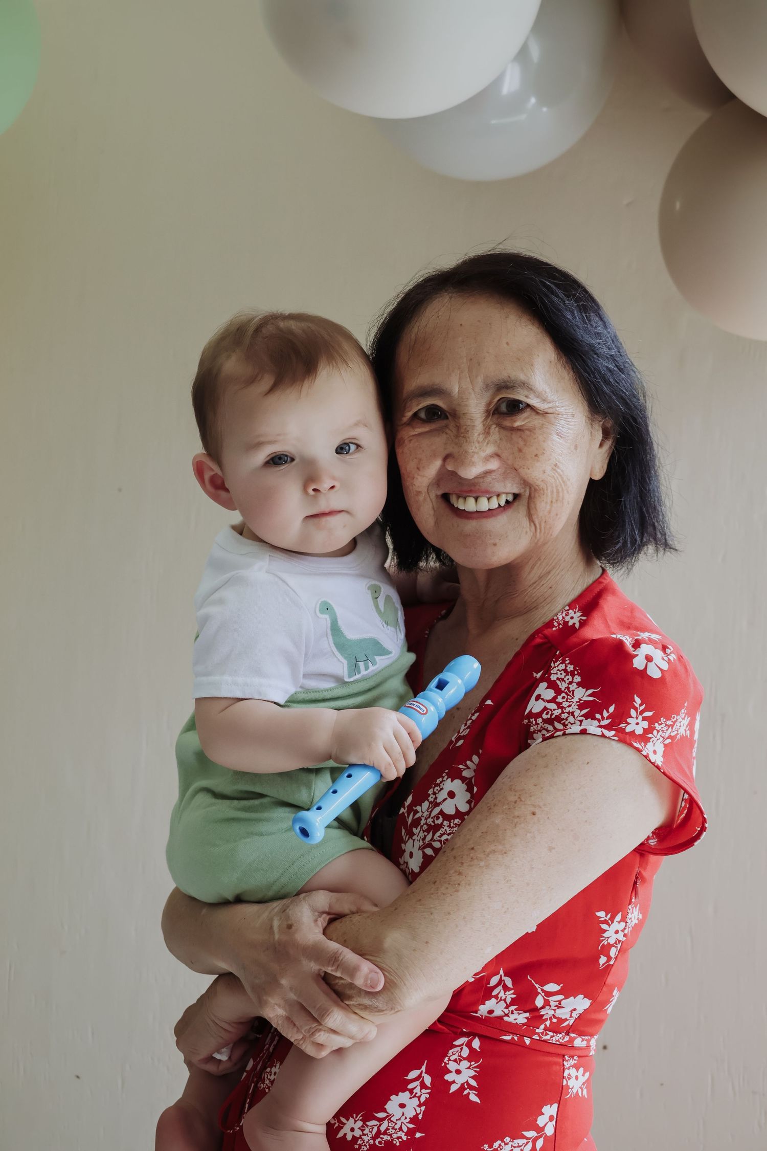 A warm family moment at a celebration with white balloons in the background.