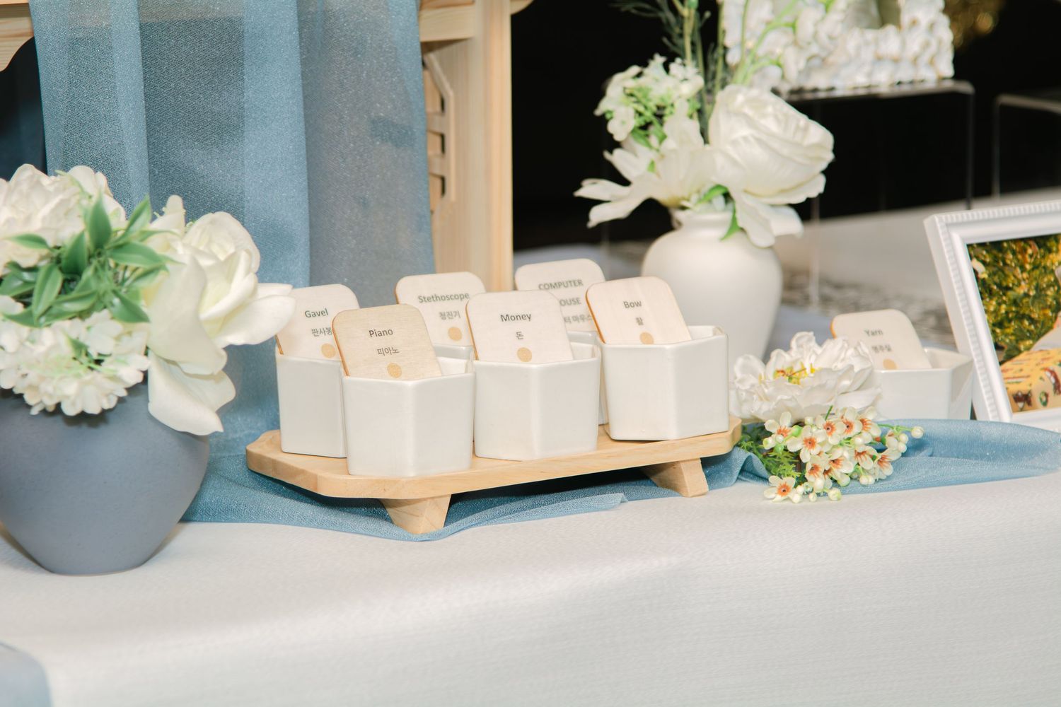 Event table decorated with white flowers and blue accents featuring delicate centerpieces.