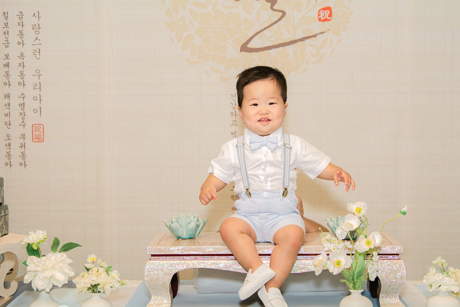 Pastel blue and white themed celebration display with traditional Asian decorative elements.