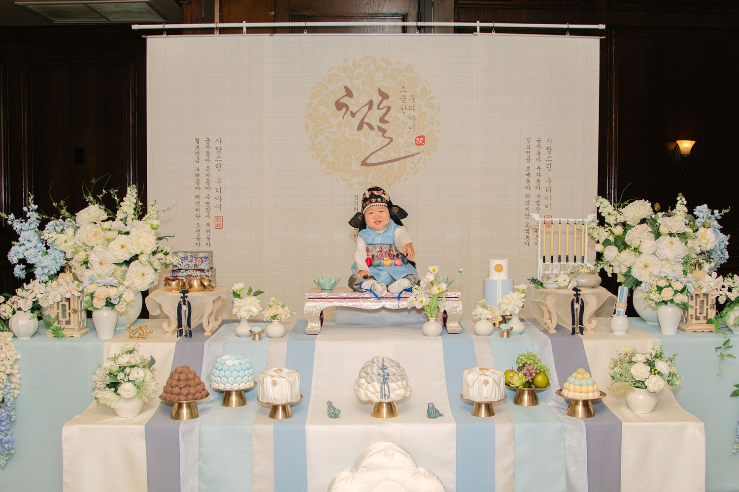 Elegant wedding reception table setup with blue and white color scheme and floral centerpieces.