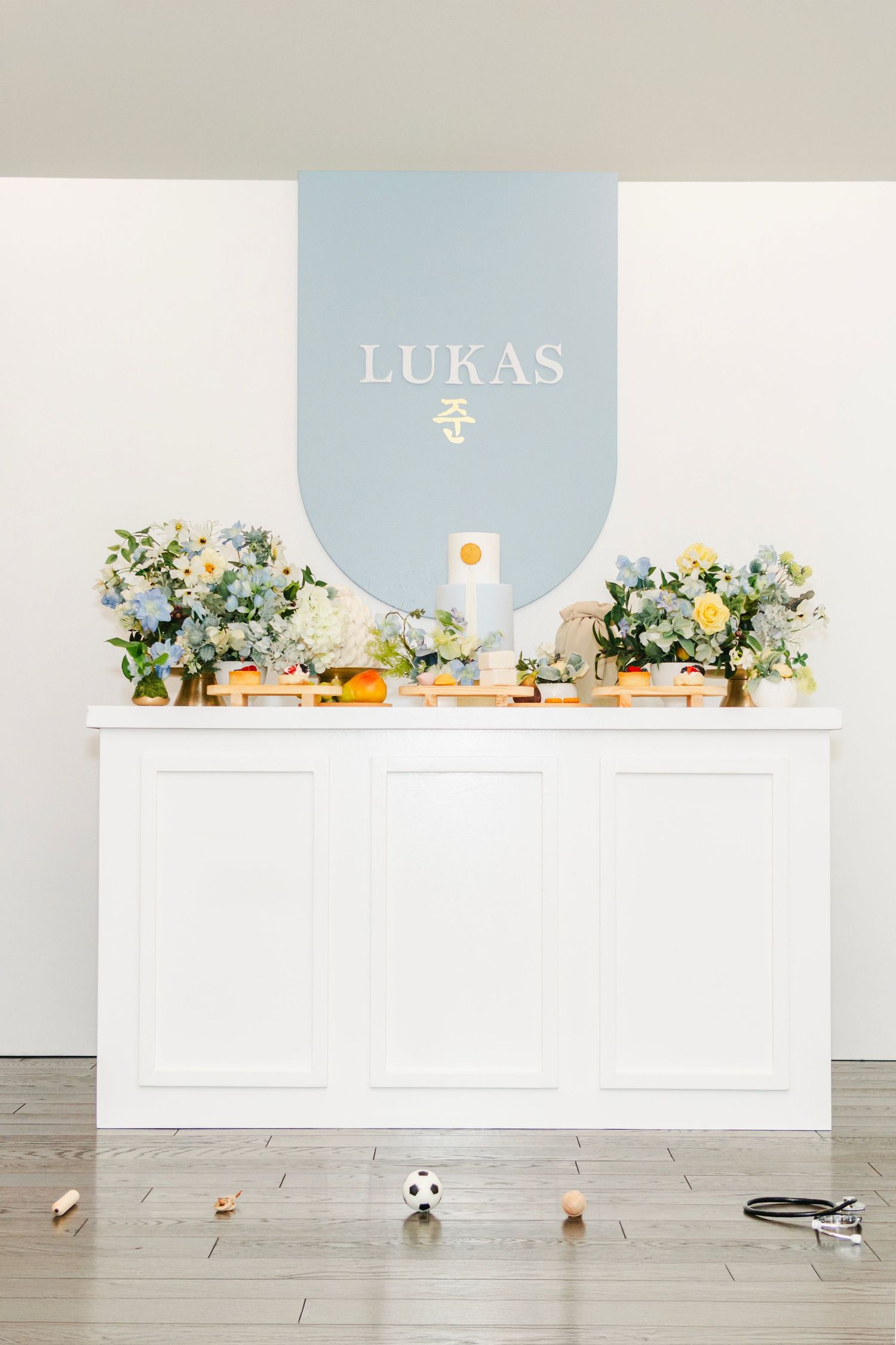 White event setup with decorative floral arrangements and toys scattered on floor.