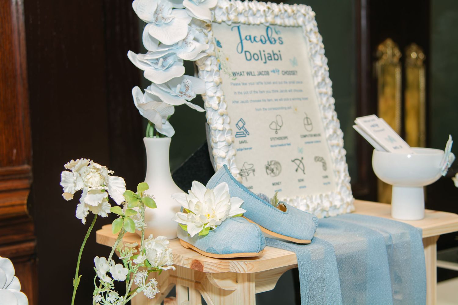 Celebration table featuring delicate floral arrangements and soft blue decorative elements.