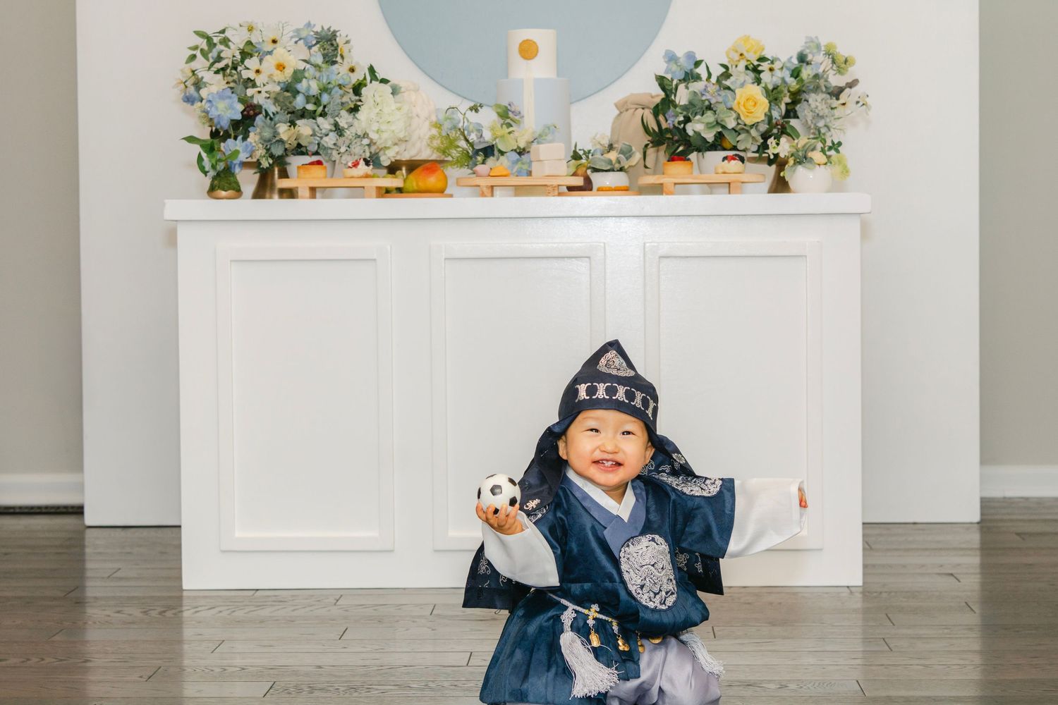 Decorated celebration space featuring floral arrangements and blue circular wall accent.