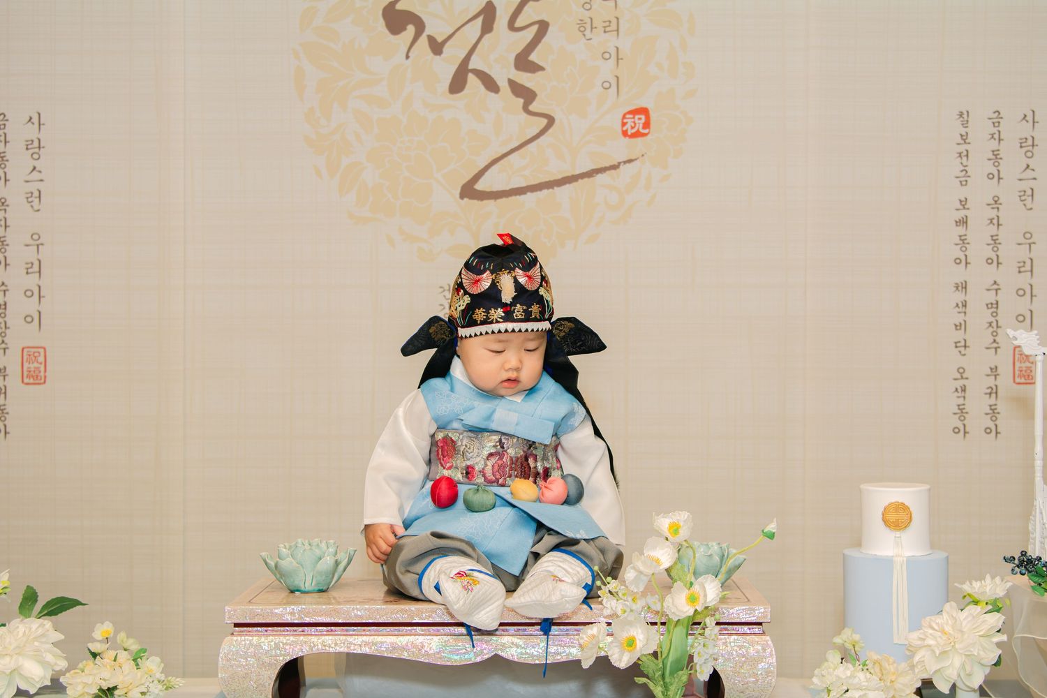 Traditional Asian celebration display with decorative panels and floral arrangements in soft colors.