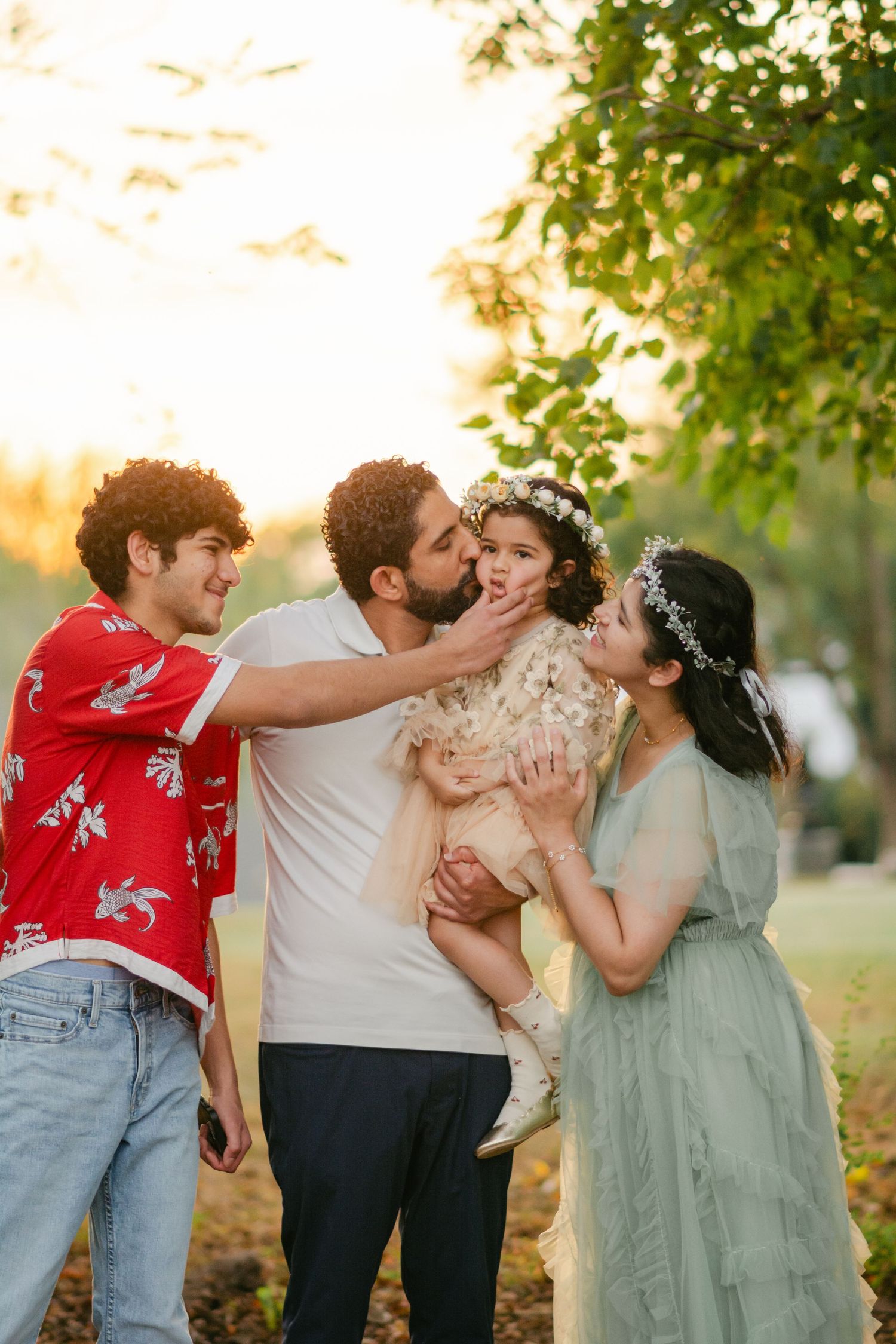 A group in coordinating outfits share joyful moments together during an outdoor photo session at sunset.