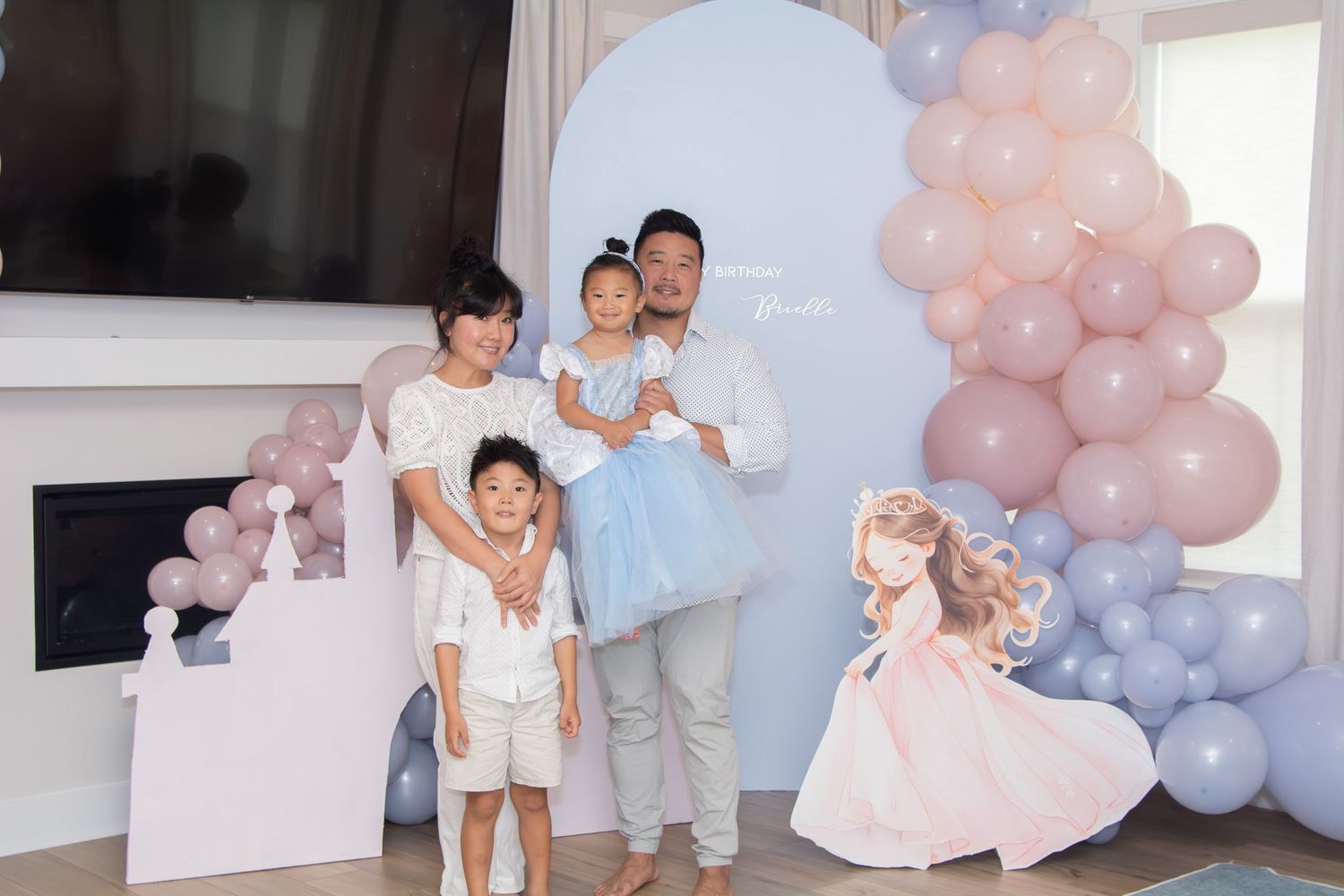 A pink and blue balloon arch decorates a room for what appears to be a gender reveal or baby shower celebration.