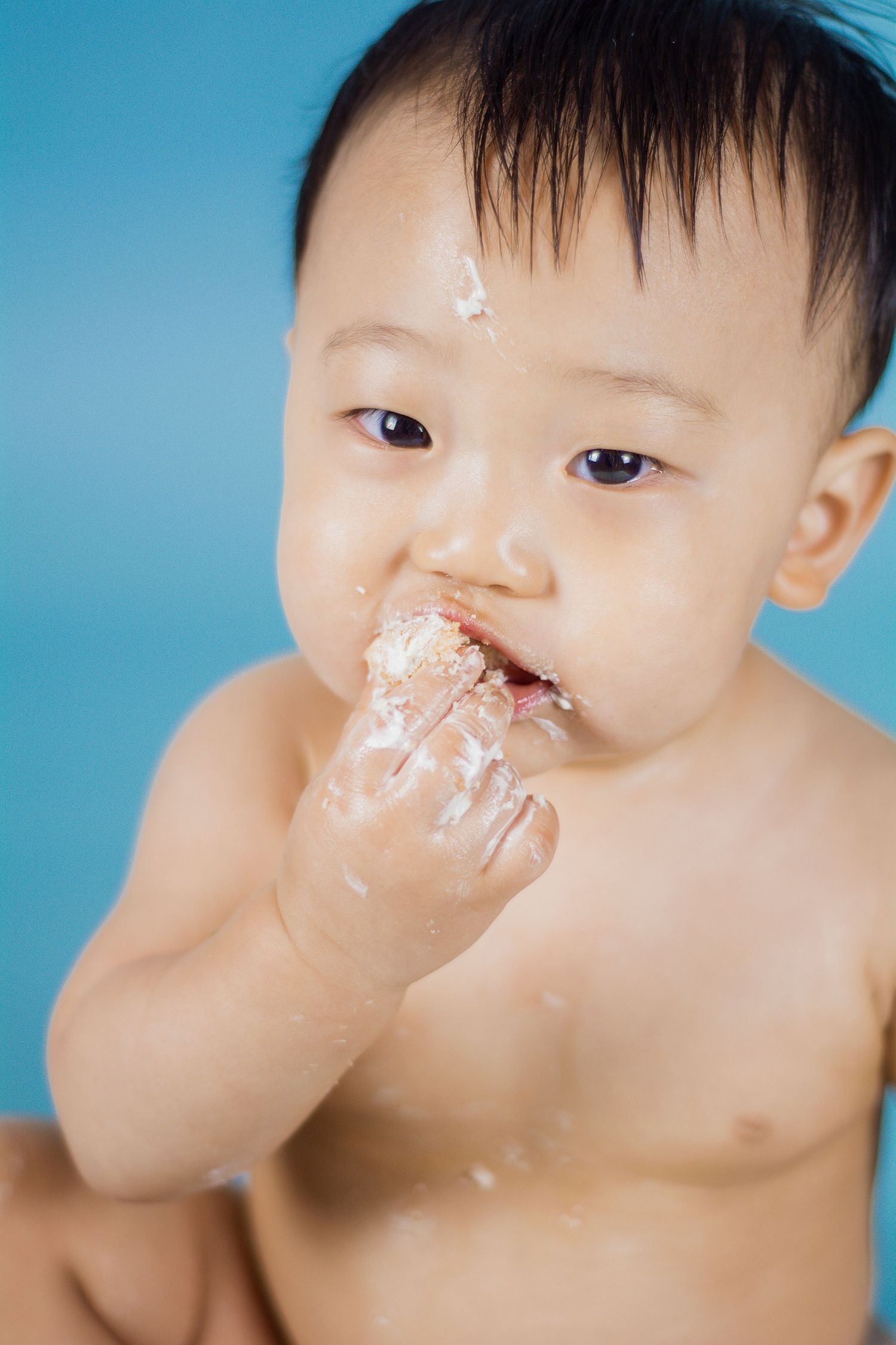 Close-up sequence showing baby's face covered in cake frosting during celebration.