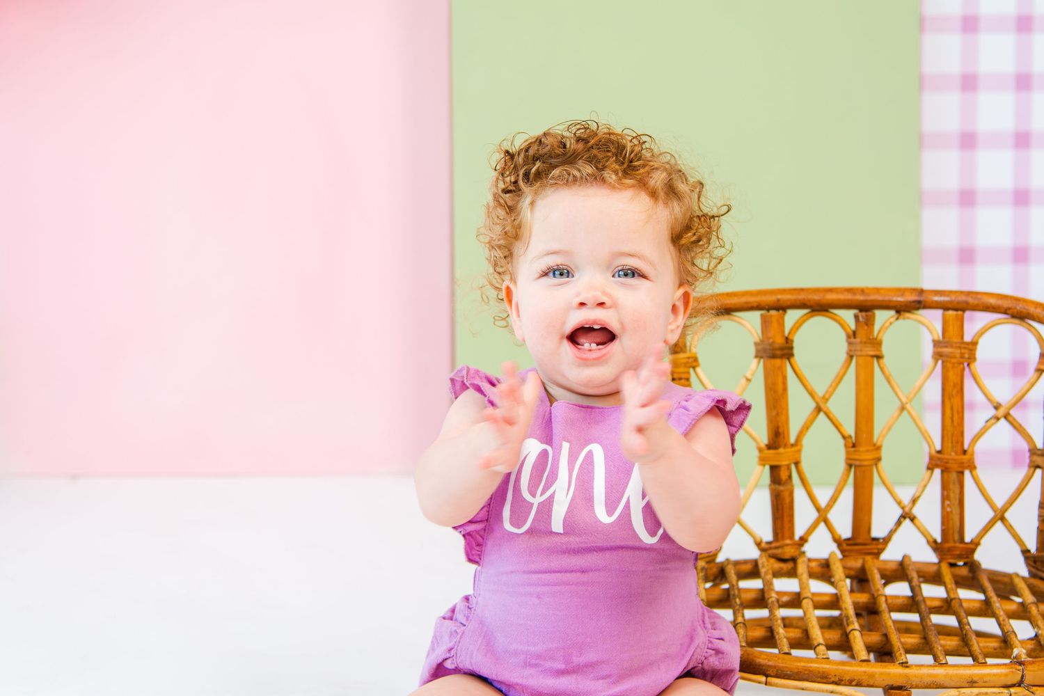 Pink and green themed baby photo with wicker furniture and checkered pattern backgrounds.