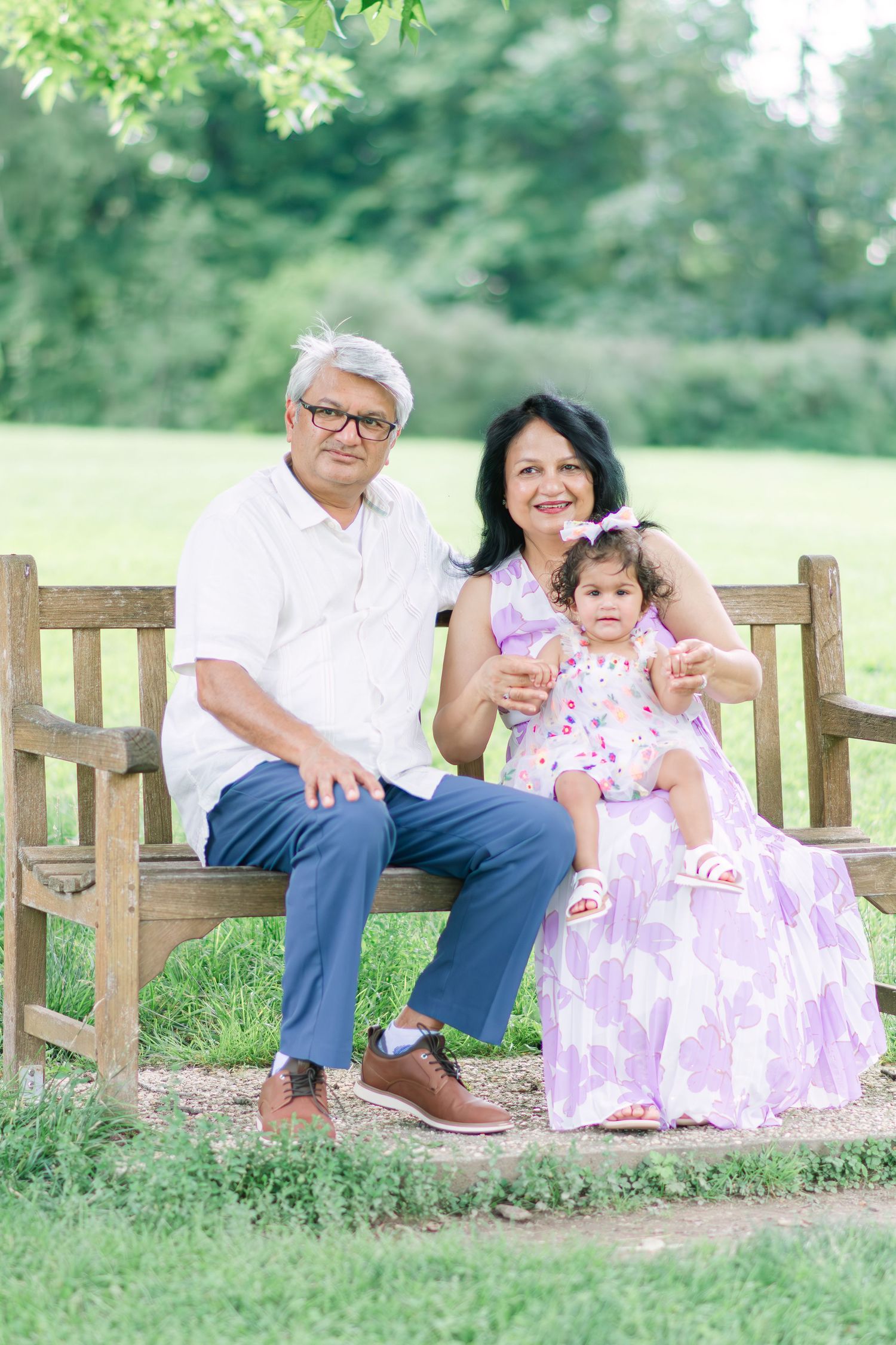Family relaxing on wooden benches in a peaceful garden setting.