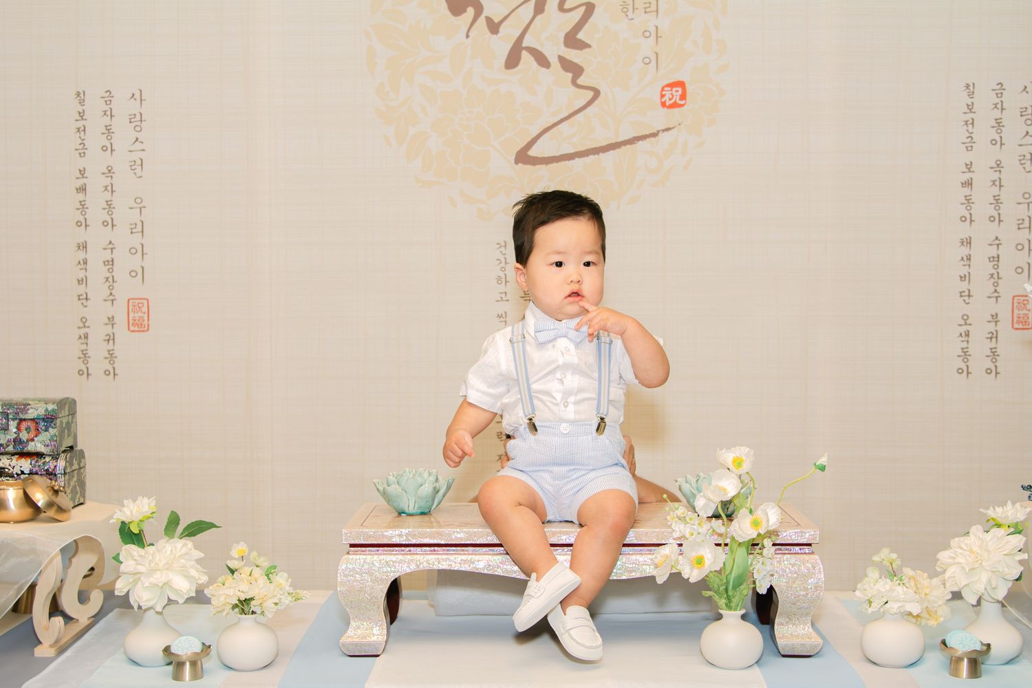 Birthday party setup with elegant floral arrangements and Asian-inspired wall art.