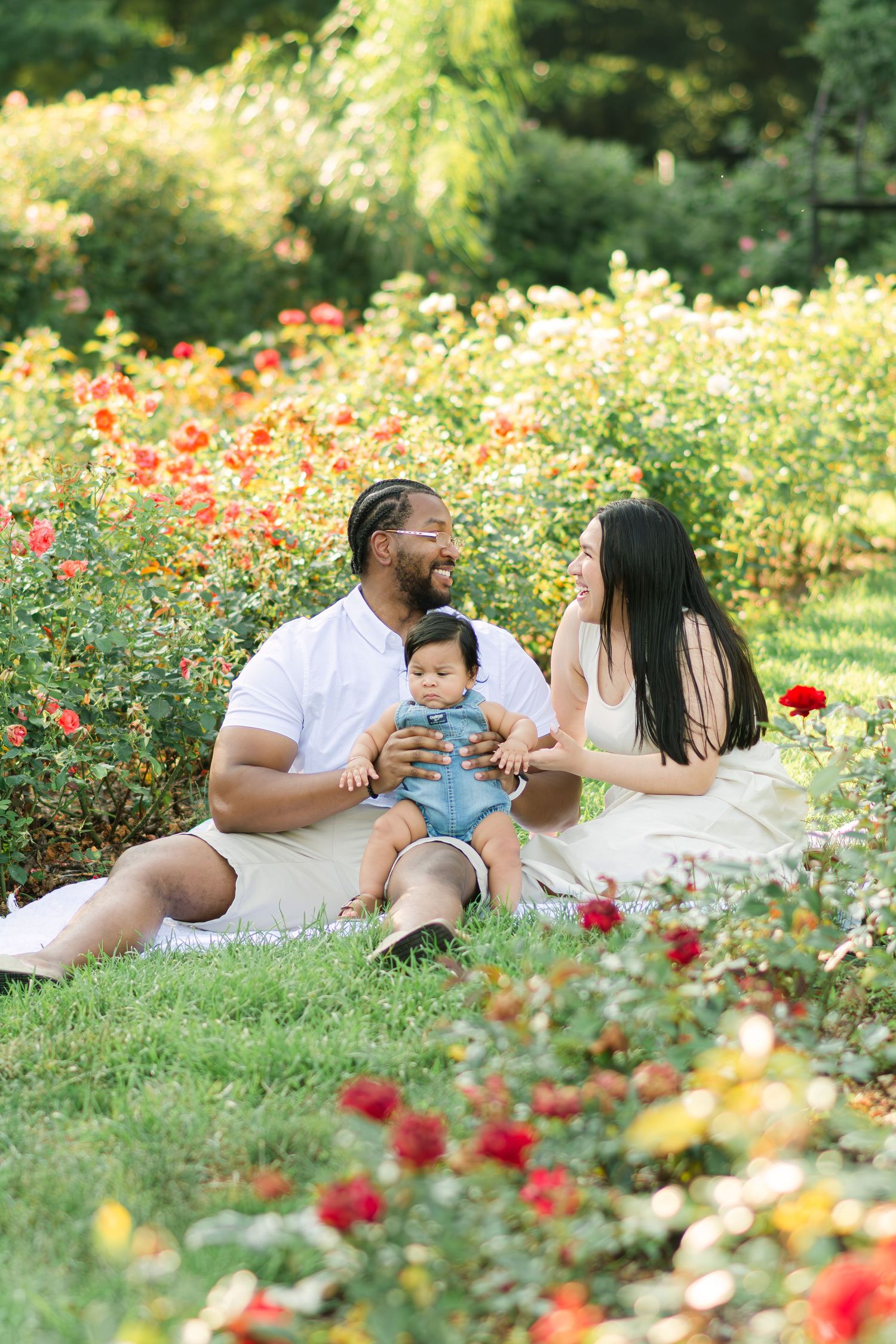 Family having a picnic among colorful roses in a summer garden.