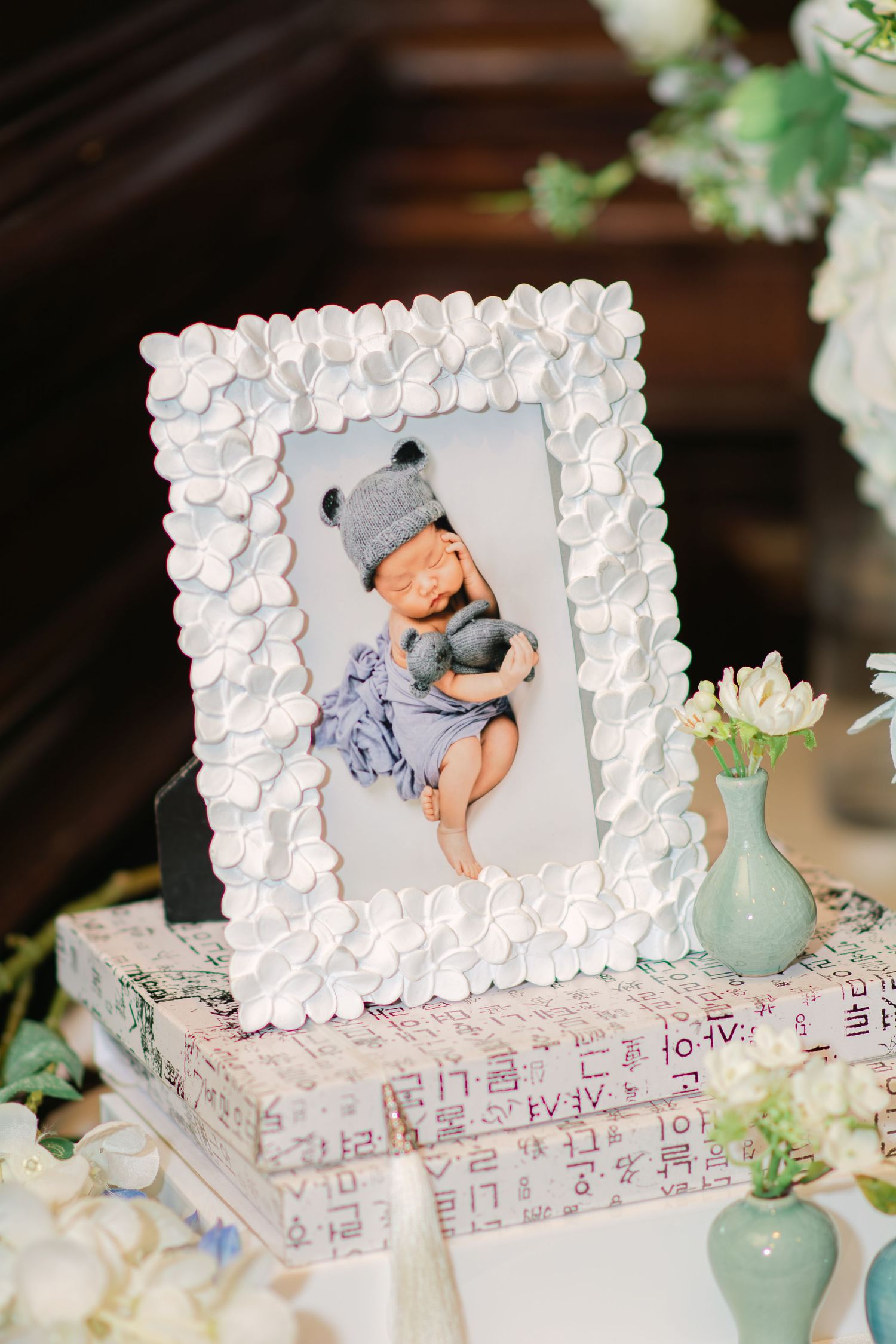 White seashell picture frames displayed on patterned boxes with mint green vases.