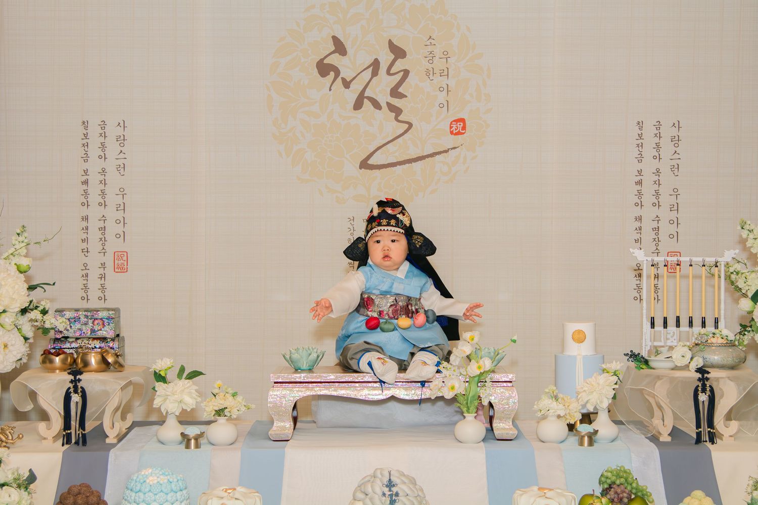 Elegant party setup with light blue and white decorative elements and floral arrangements displayed on a long table.