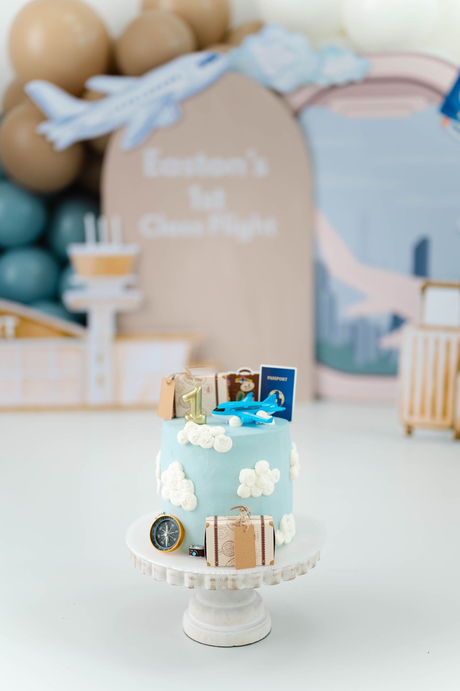 A collection of miniature wooden houses and architectural models arranged on a white surface with soft lighting and pastel colors.