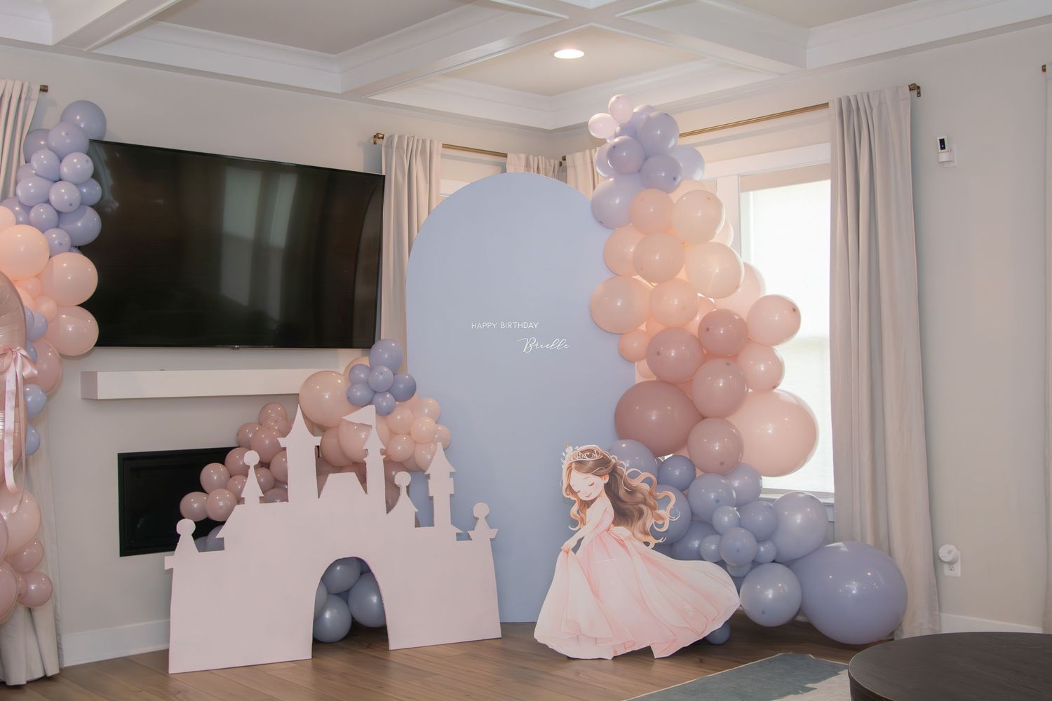 Blue and peach balloon garlands decorate a white interior space for an elegant event setup.