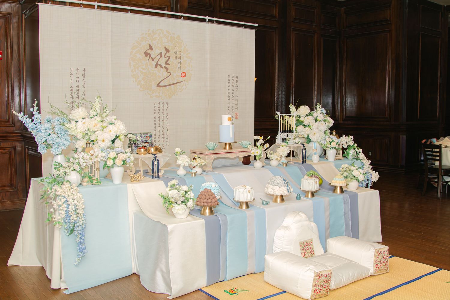 Wide view of an elegant event space with coordinated blue and white table settings.