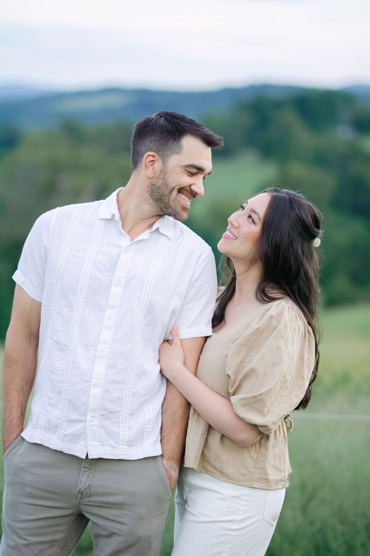 Couple sharing laughs and intimate moments in a rustic outdoor setting.