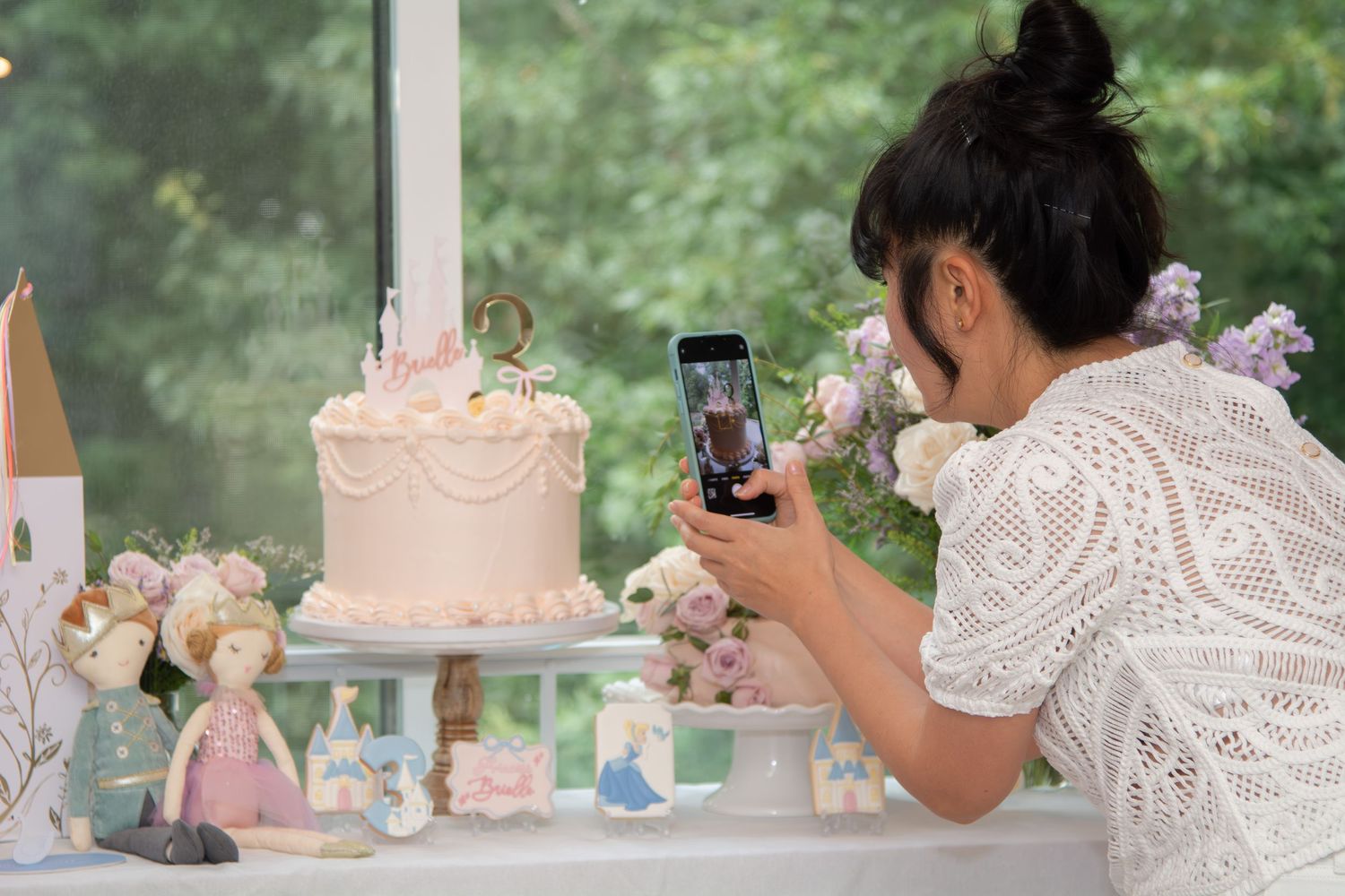 A wedding photographer captures candid moments during a romantic outdoor celebration with pastel decor.