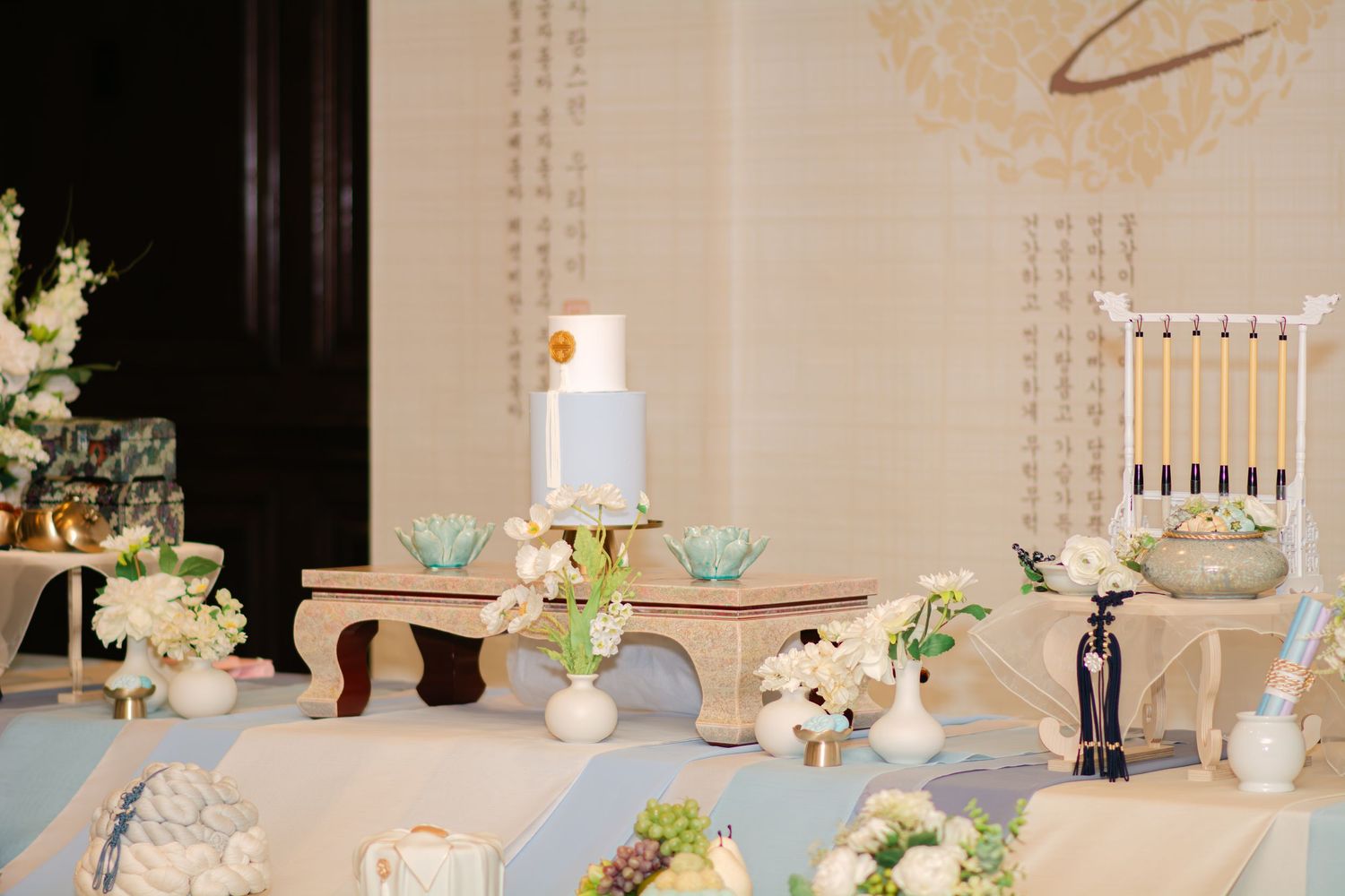 Elegant white table setting with floral centerpieces and delicate teacups.