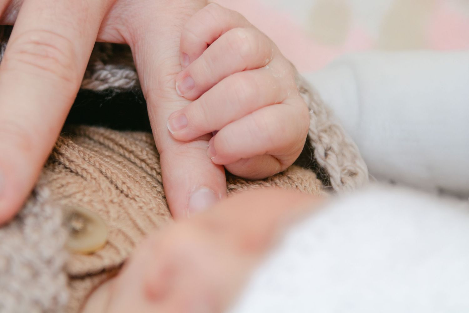 Close-up detail of hands gently touching soft fabric.