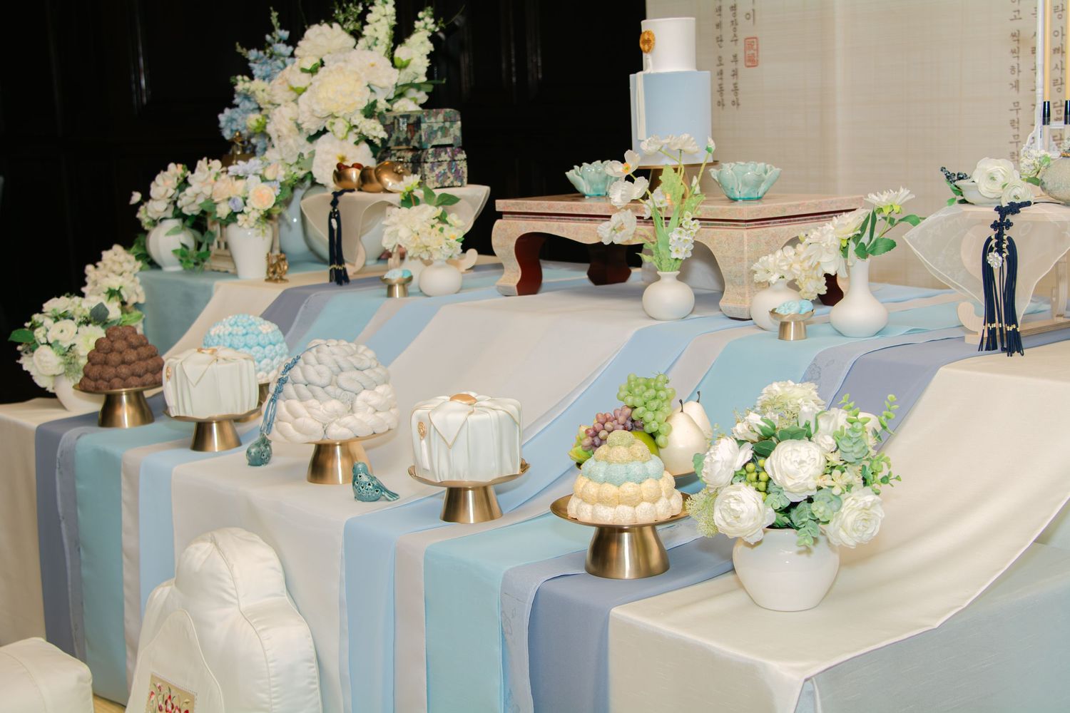 Elegant baby shower table decorated with white flowers and soft blue accents.