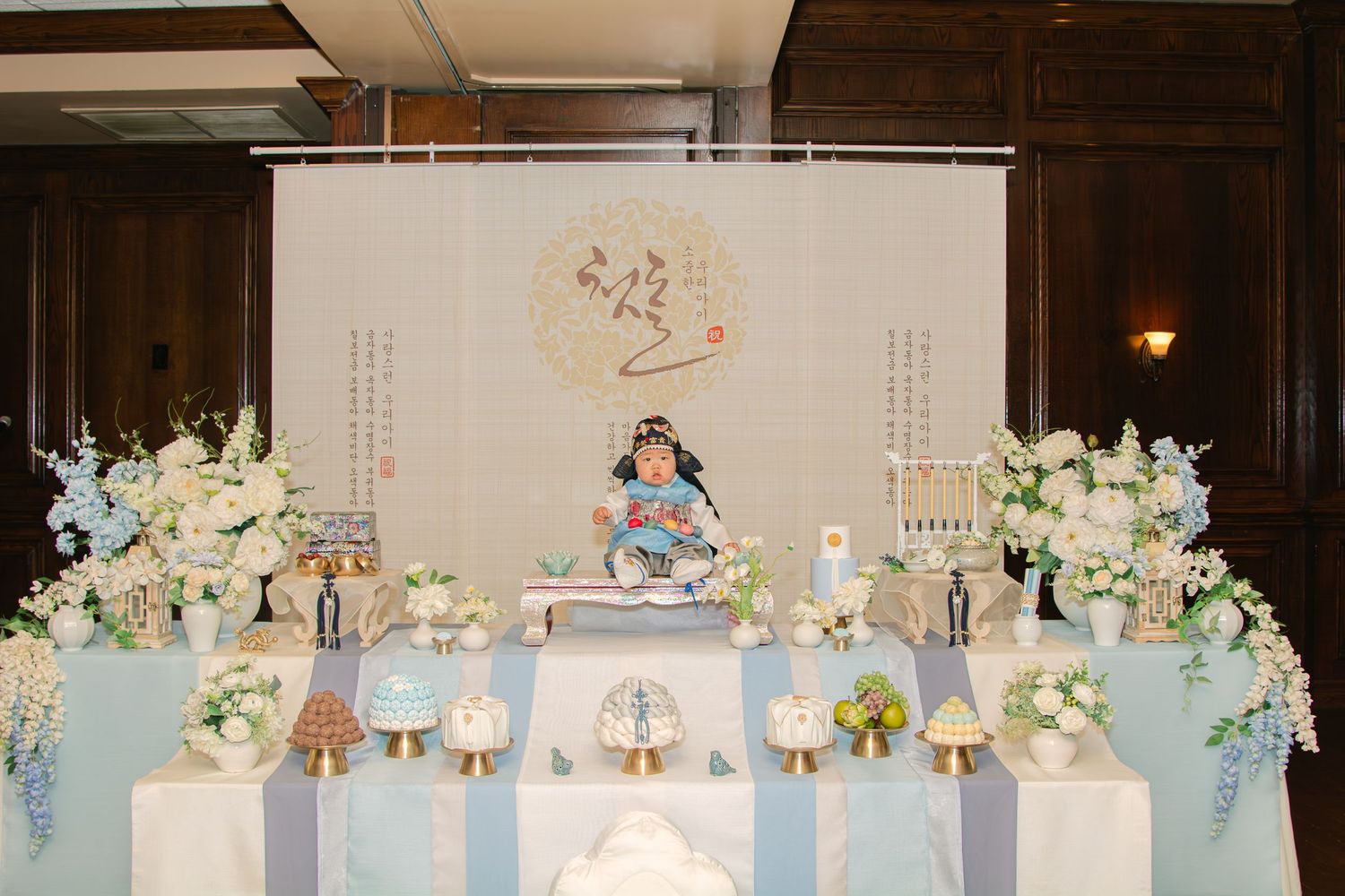 Wide angle view of an elaborate Korean first birthday celebration table with traditional decorations.