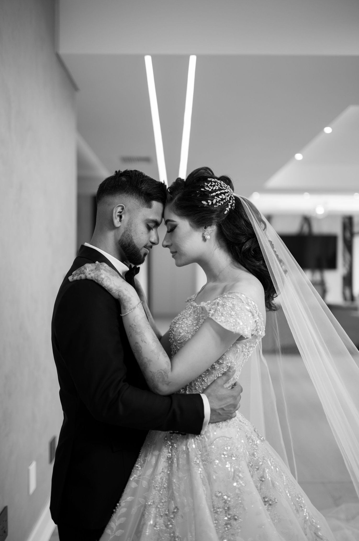 Black and white intimate portrait of couple sharing tender moment at wedding.