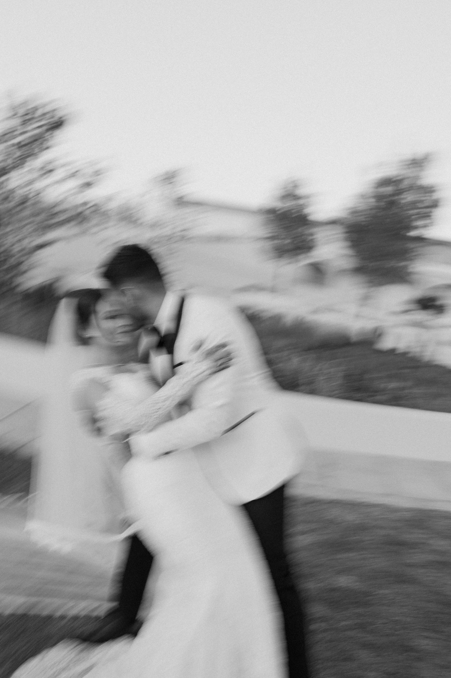 Artistic motion blur capture of romantic wedding moment outdoors.