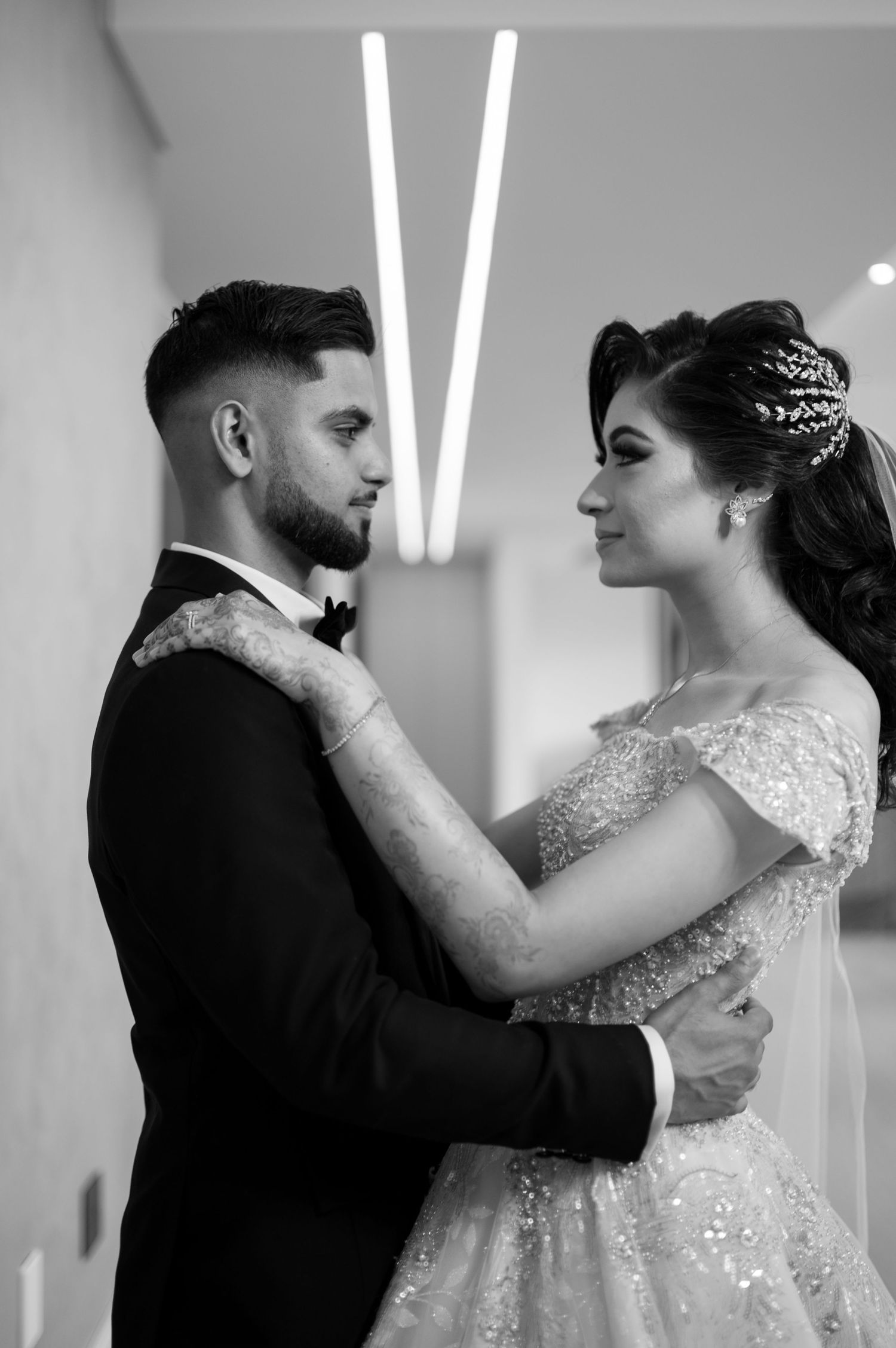 A romantic dance pose between newlyweds under modern lighting.