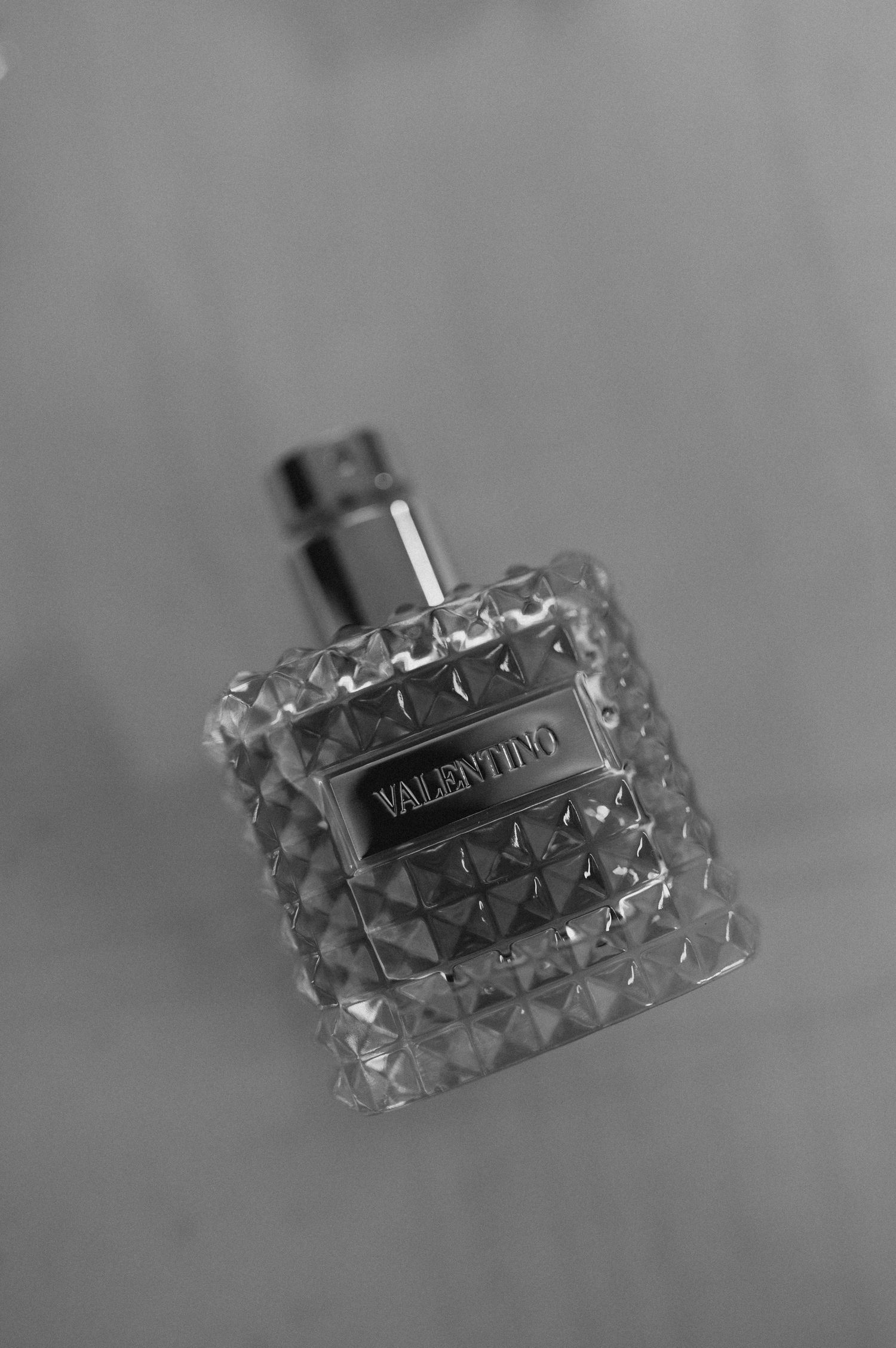 Close-up of a Valentino perfume bottle with textured glass design in black and white.