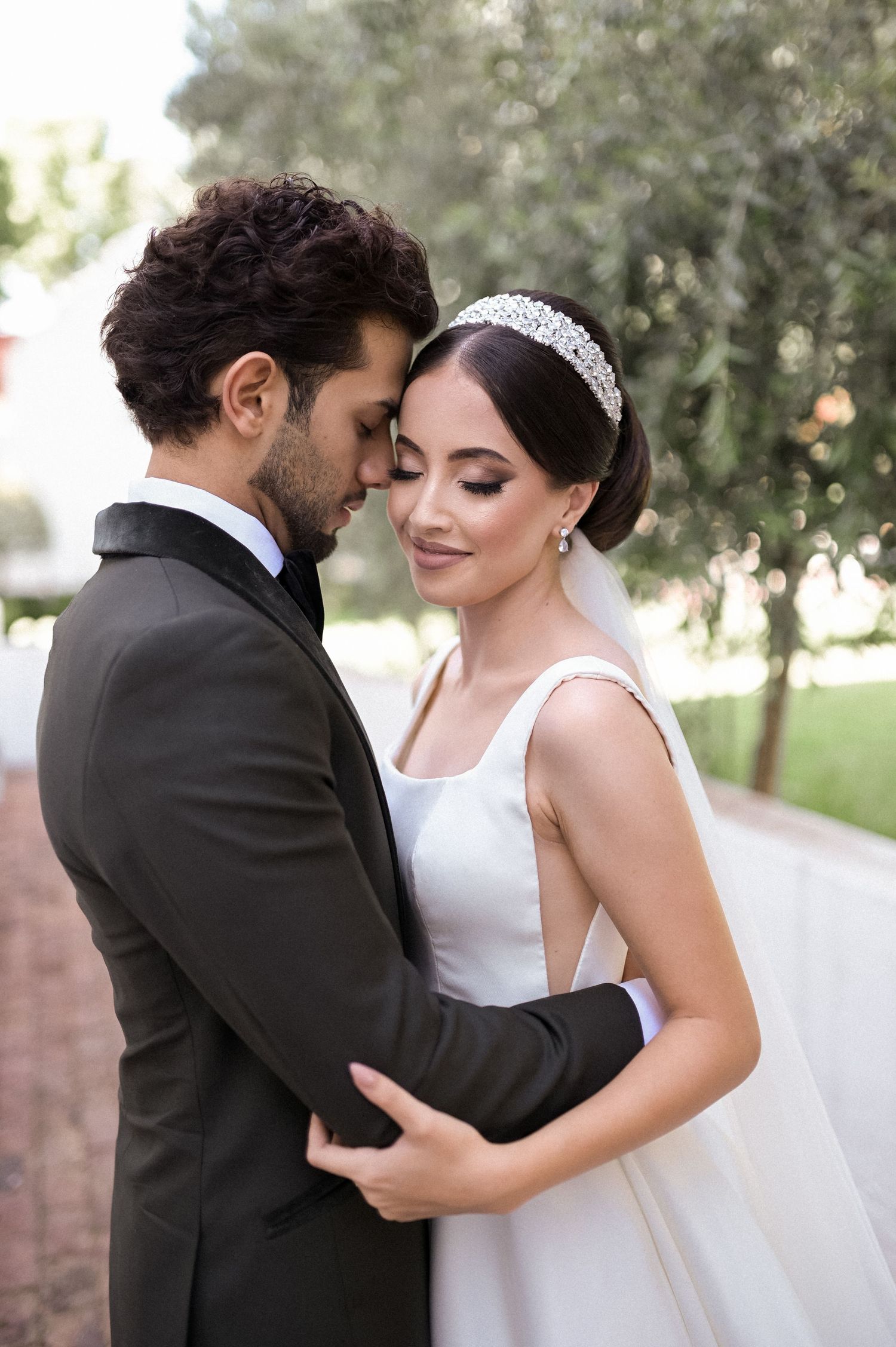 Elegant couple shares intimate moment in garden wedding setting.