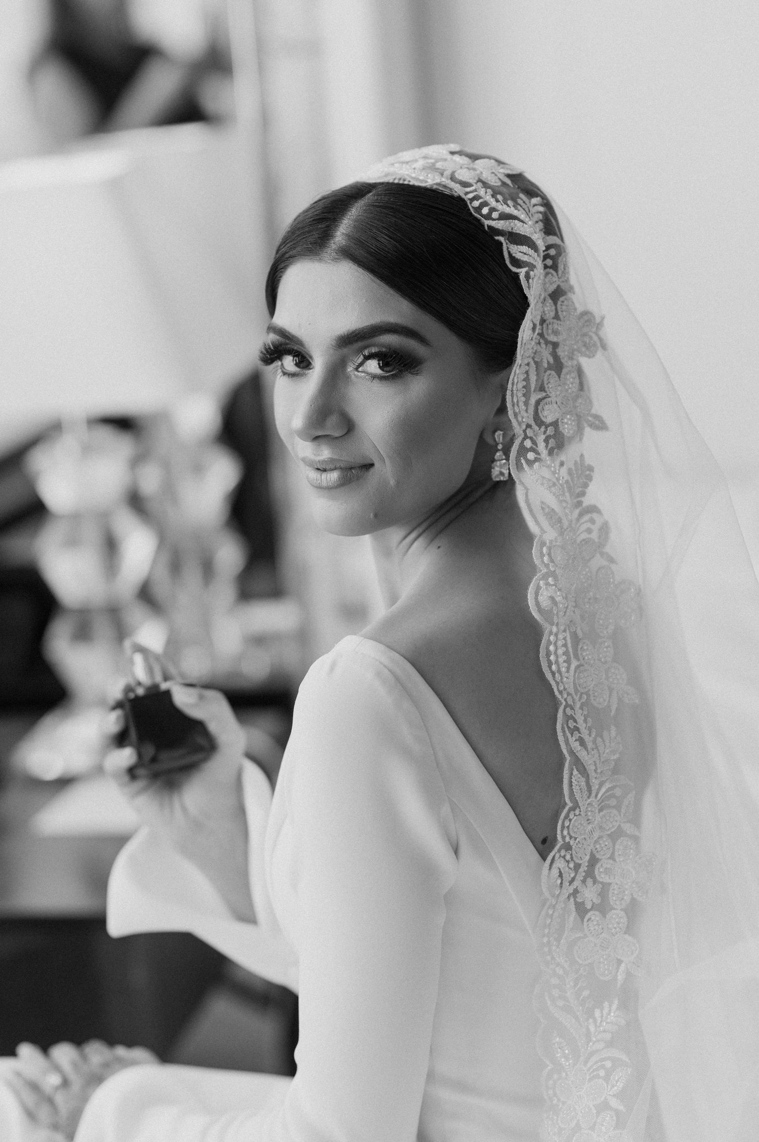 A stunning bridal portrait featuring an elegant lace veil and classic white wedding gown.