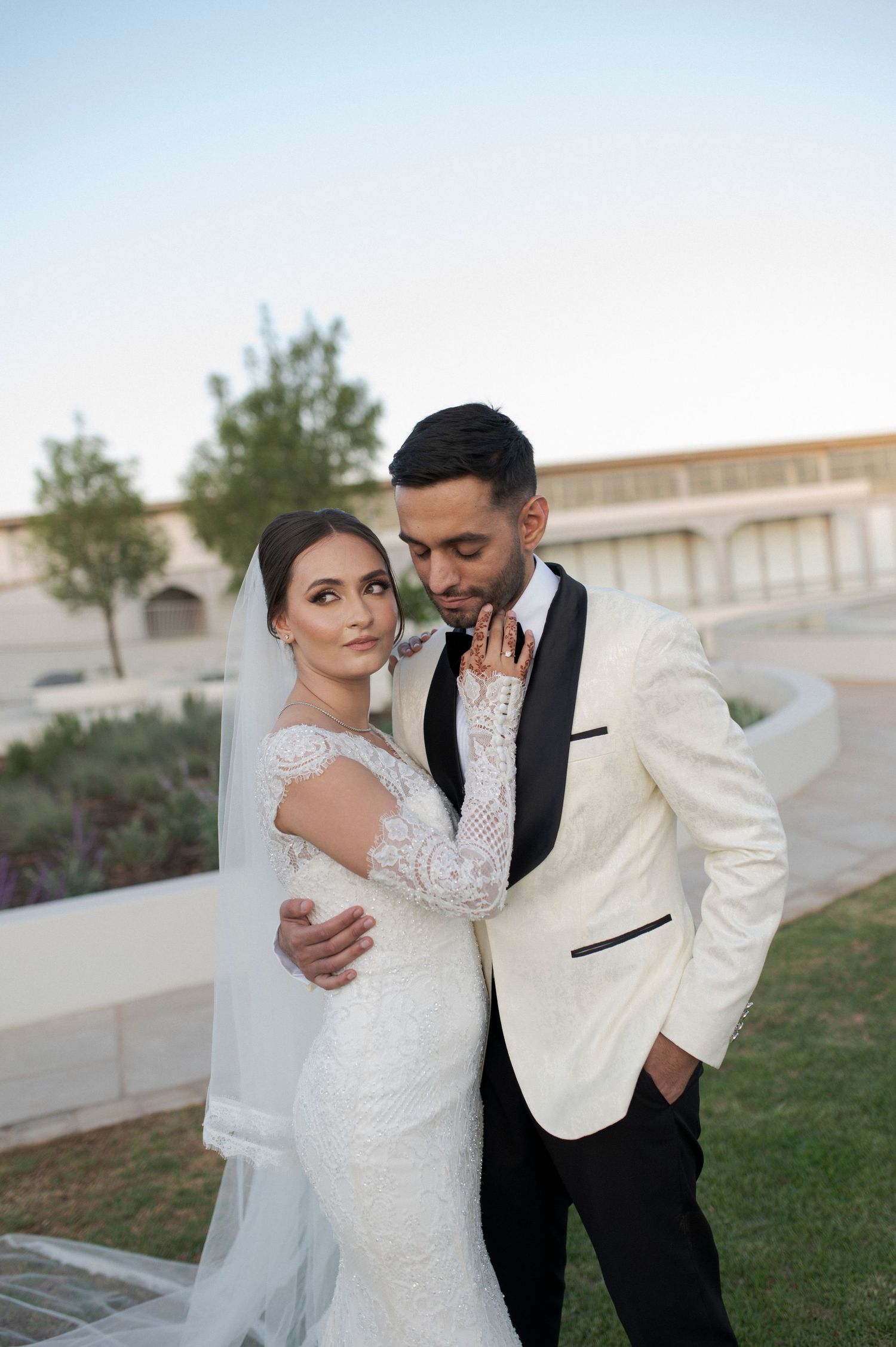 Intimate wedding portrait against modern architectural backdrop.