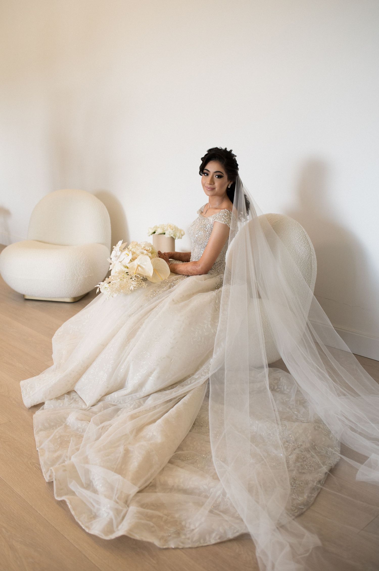 Wedding dress with flowing tulle and lace details photographed in minimalist setting.