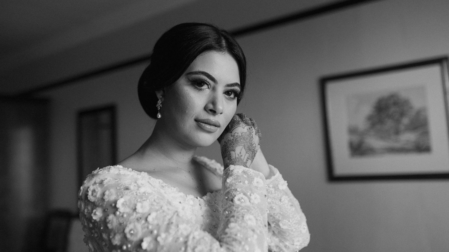 A black and white bridal portrait showing delicate lace details and elegant styling.