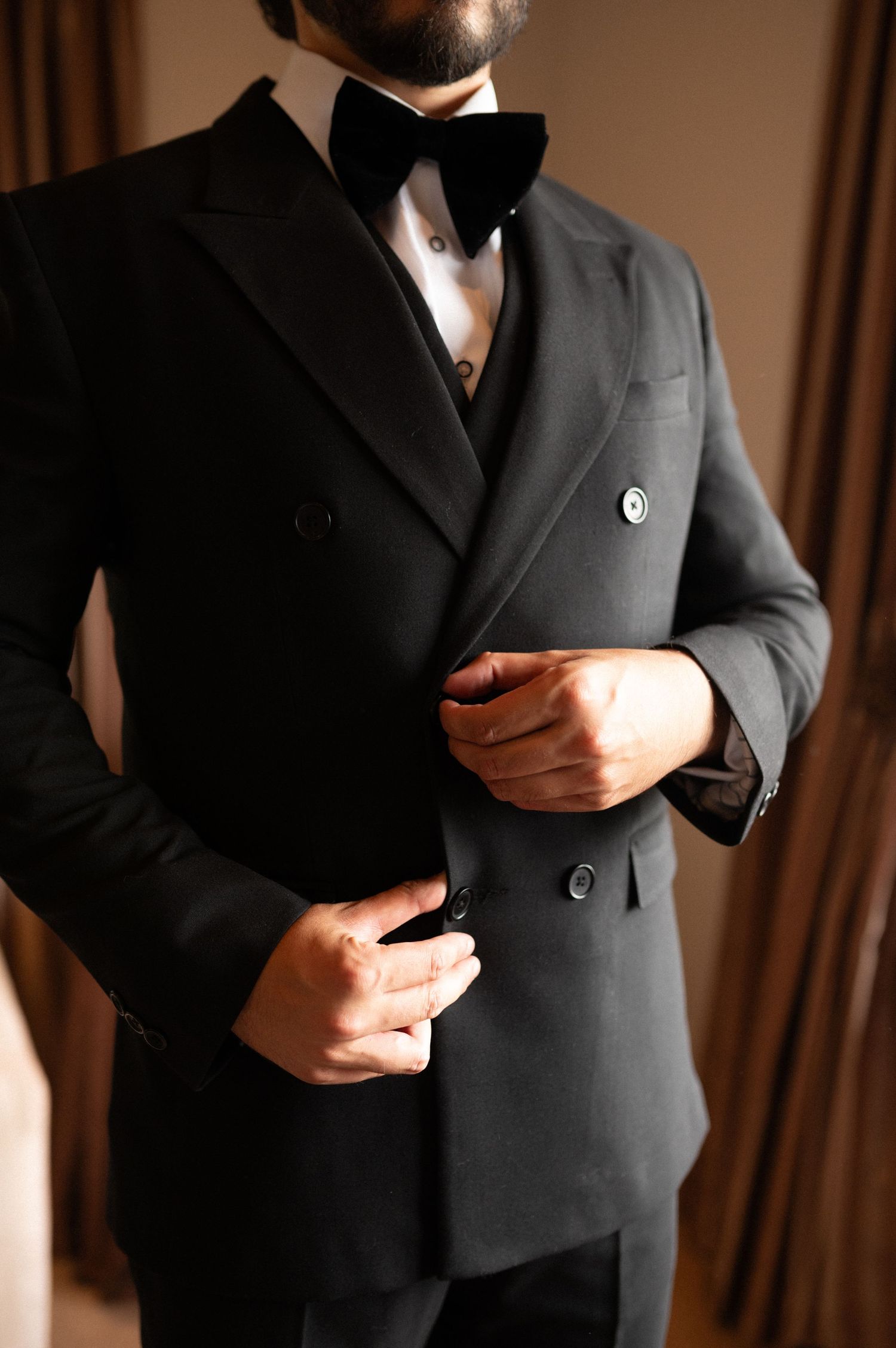 Close-up of a classic black double-breasted tuxedo with bow tie.