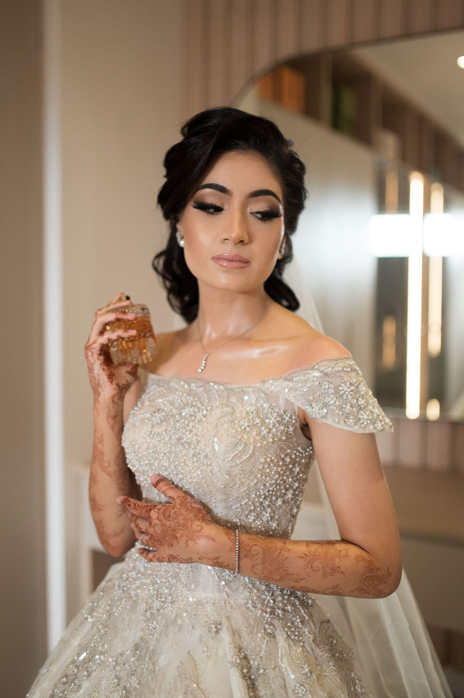 Bridal portrait showcasing intricate beaded gown and traditional henna designs.