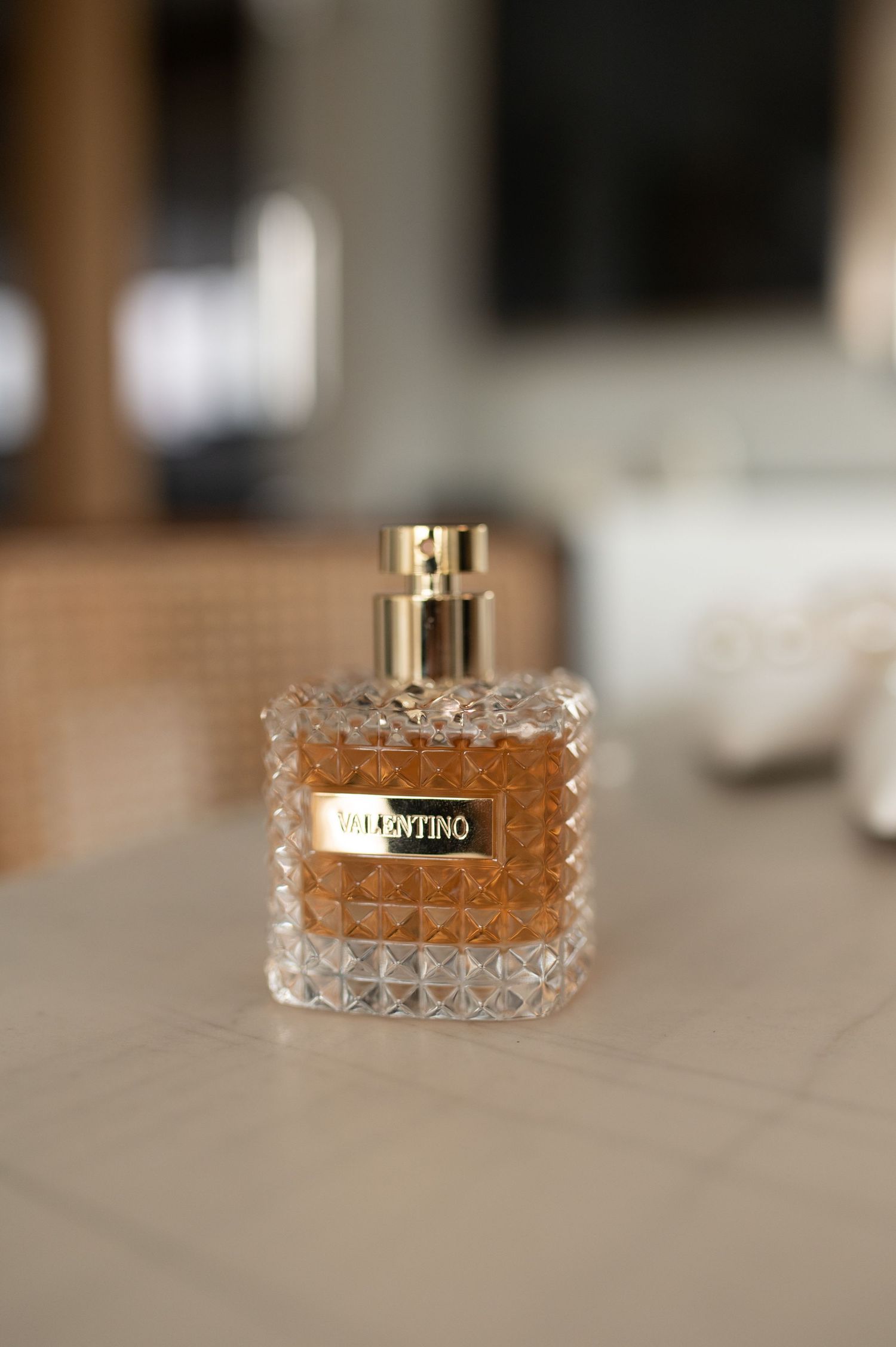 Crystal textured Valentino perfume bottle displayed on light surface.