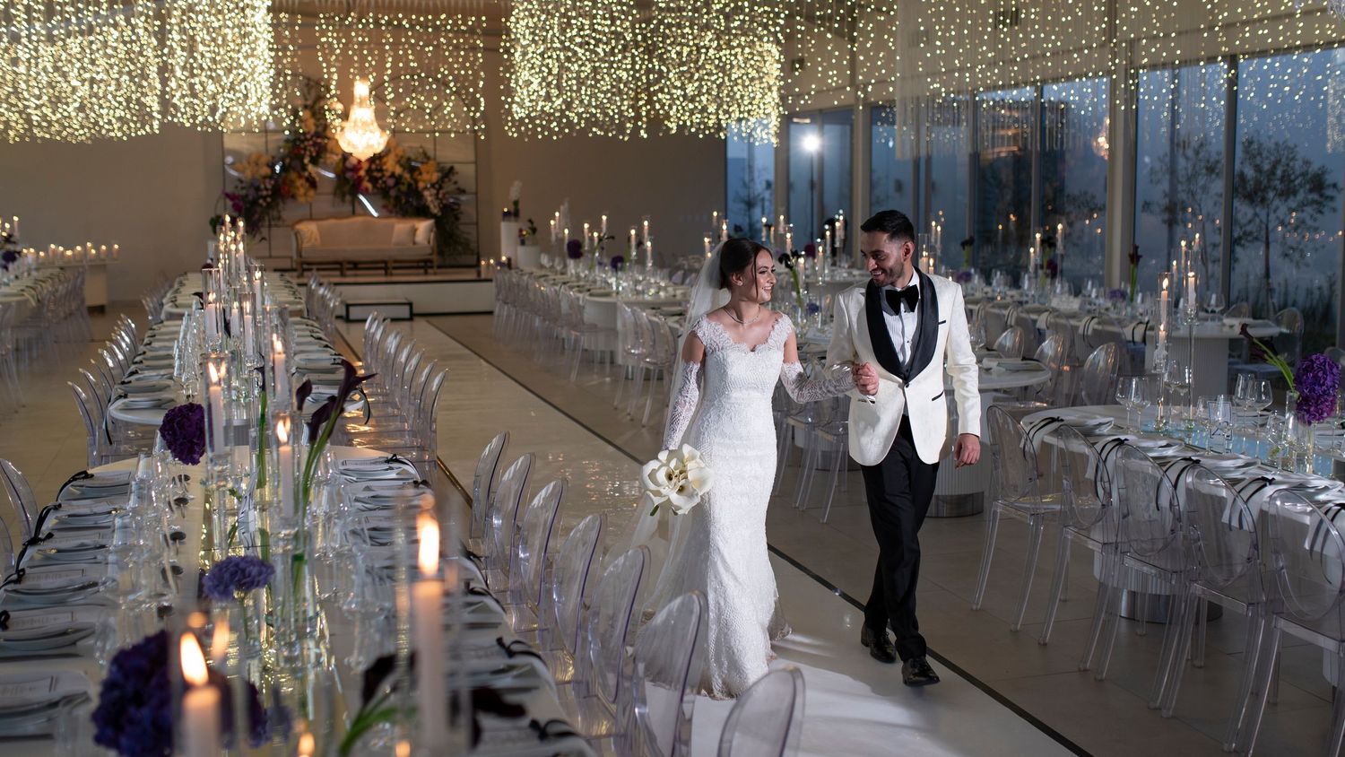 Wedding reception venue with crystal lighting and elegant table settings awaits the celebration.