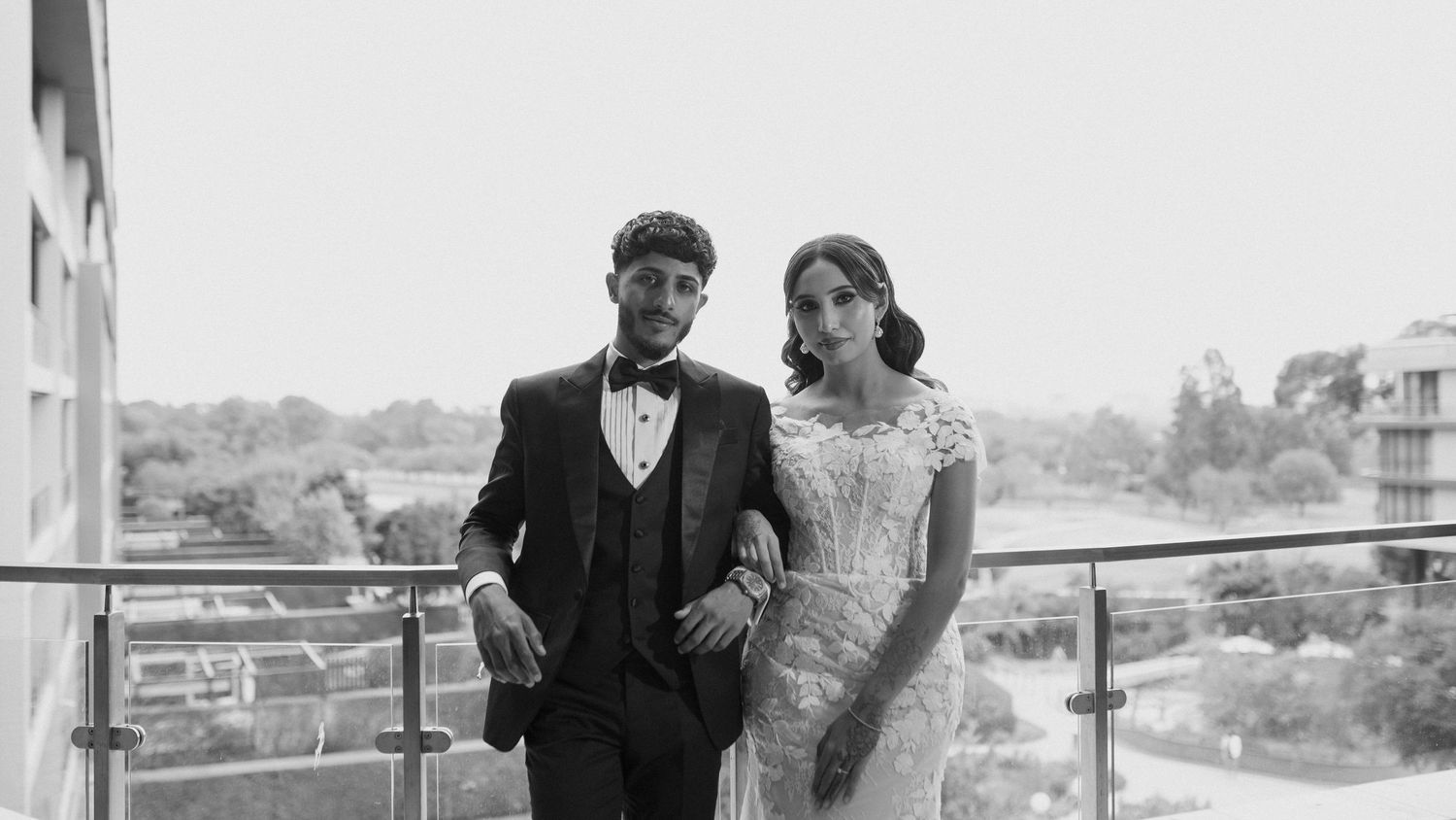Romantic black and white portrait of a couple on their wedding day on an outdoor balcony.
