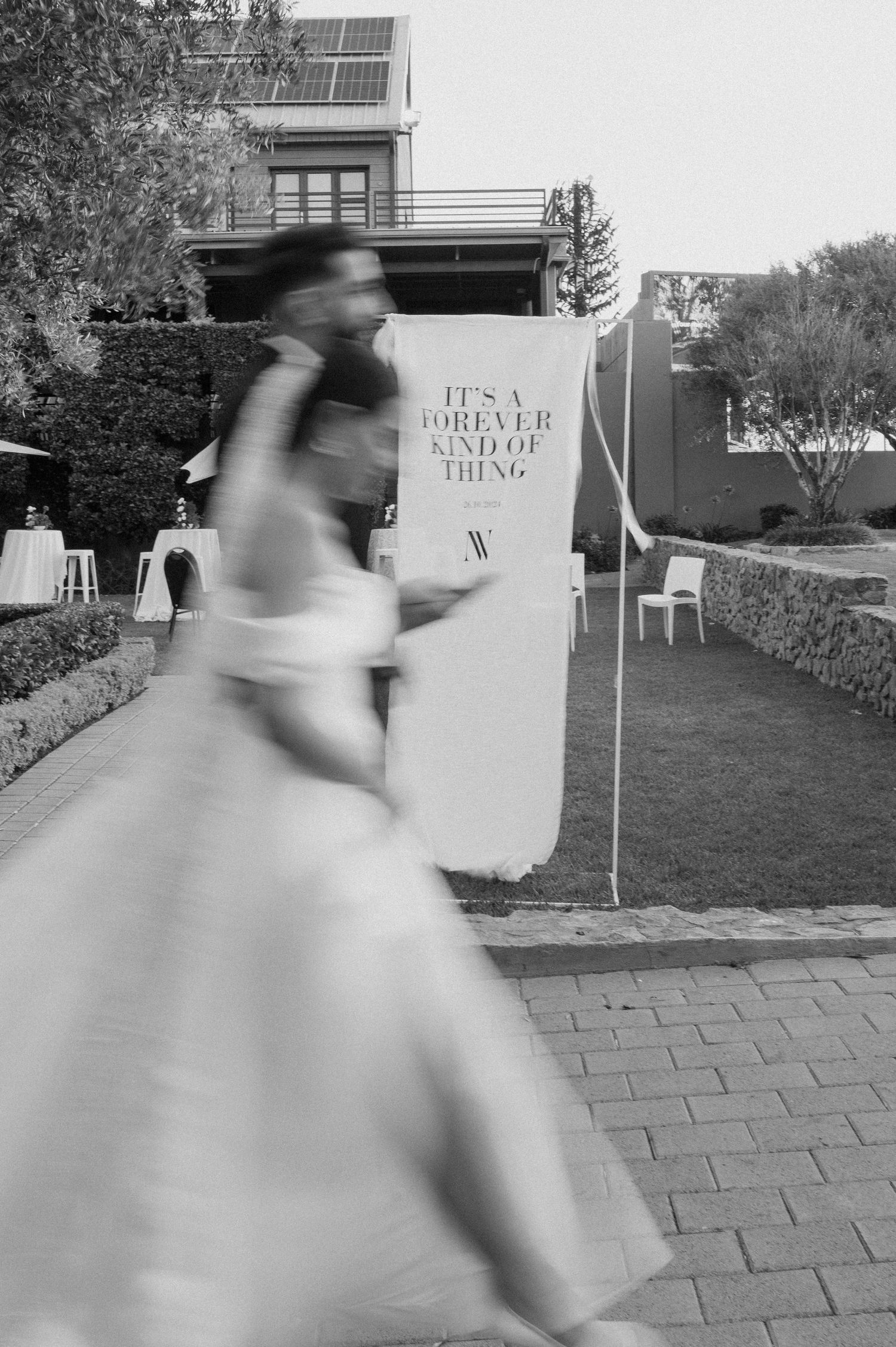 Artistic black and white motion blur photograph in an outdoor garden setting.