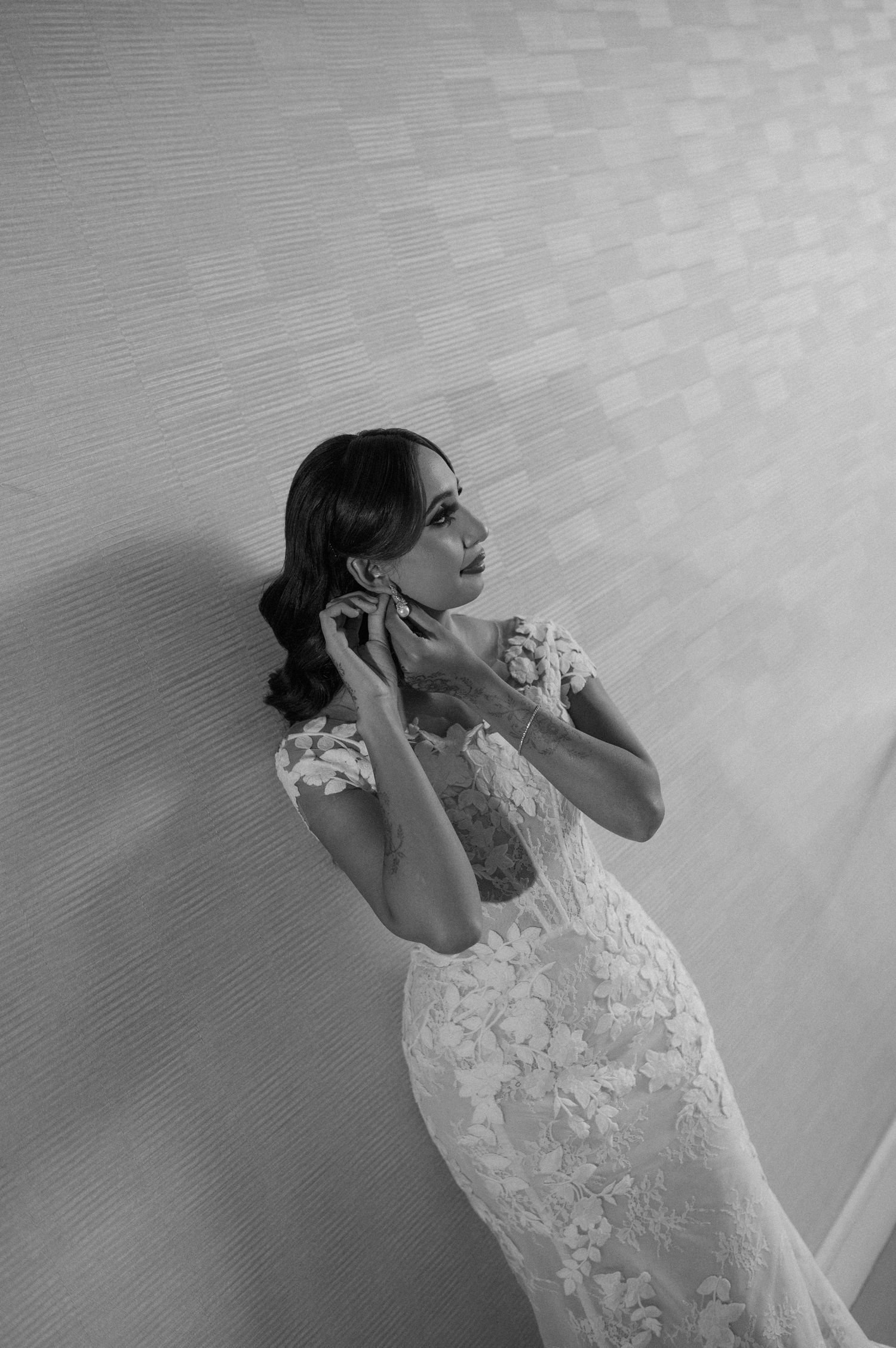 Black and white portrait showcasing intricate details of a lace wedding gown.