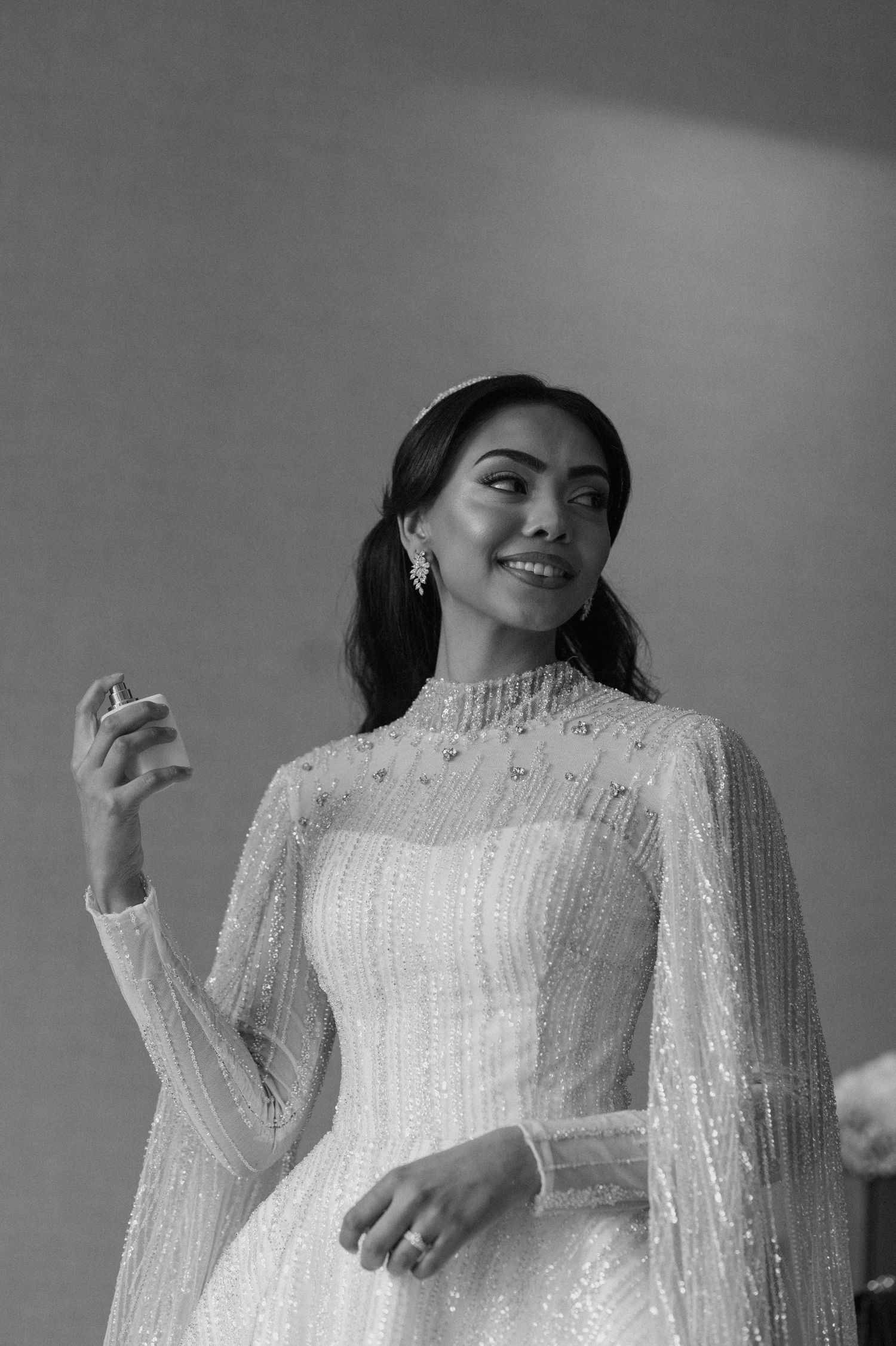 Black and white portrait of bride in Victorian-style beaded gown with high neckline.
